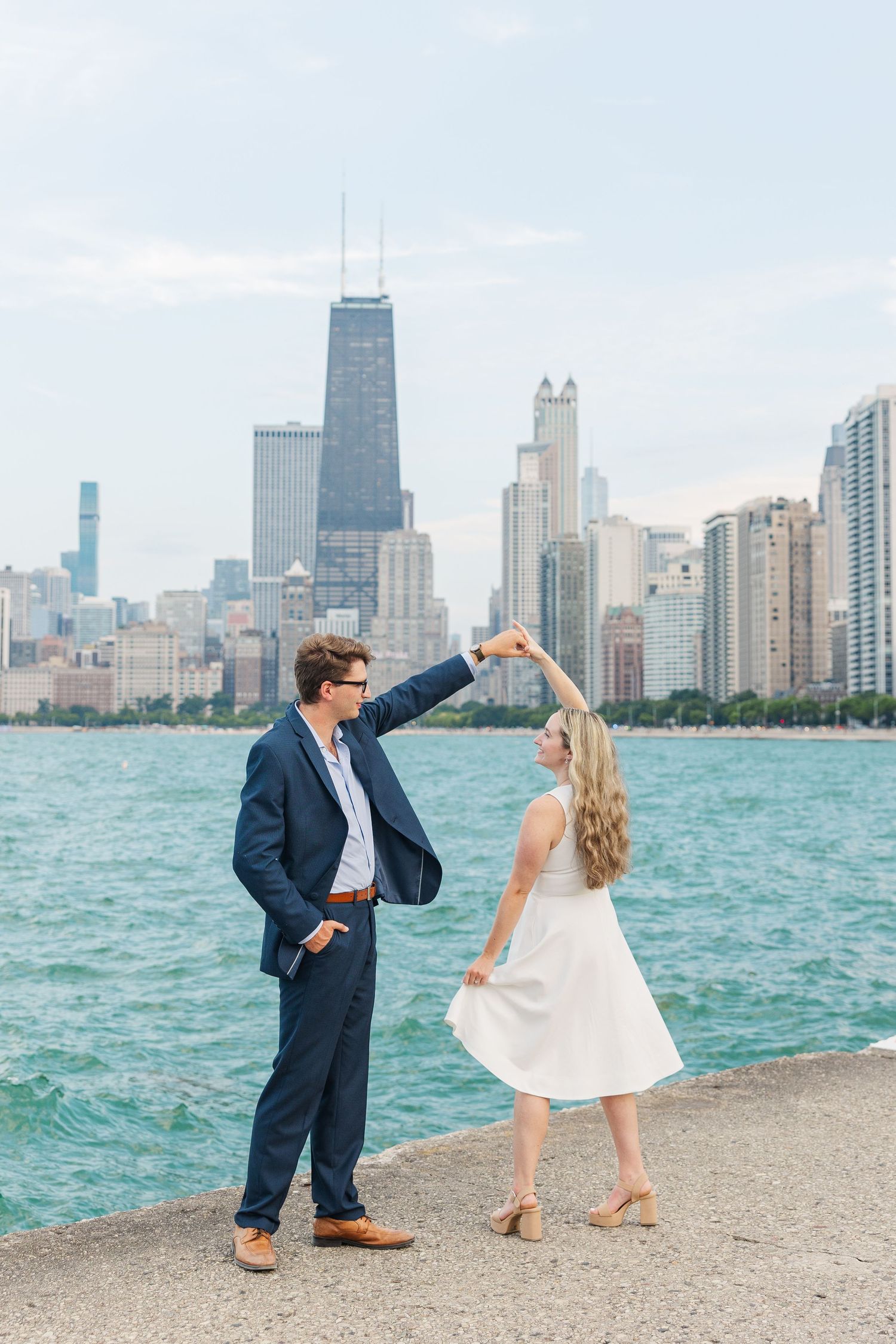 Elizabeth and Joe dancing with the Chicago skyline in the background at North Avenue Beach during sunset