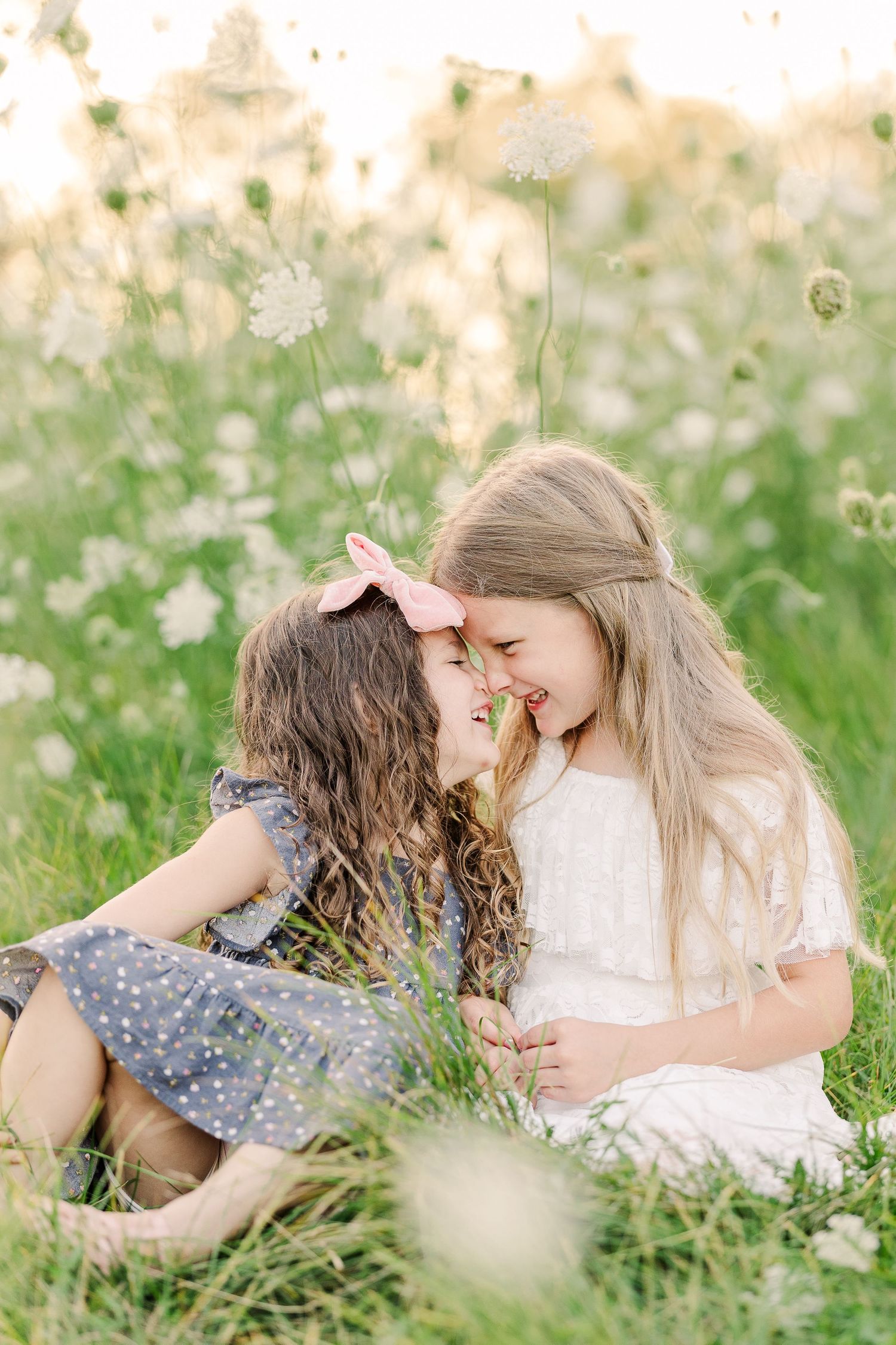 A tender moment shared between two in a meadow filled with white Queen Anne's Lace flowers.