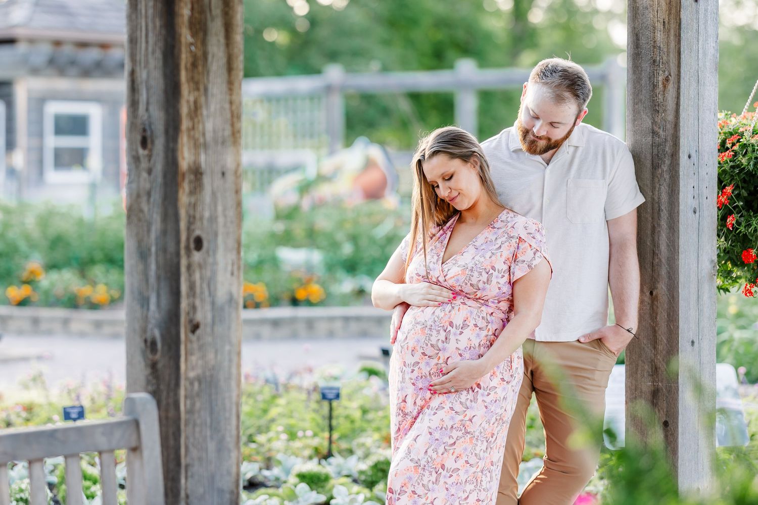 Expecting parents walking through colorful summer gardens during a Cantigny maternity session in Wheaton