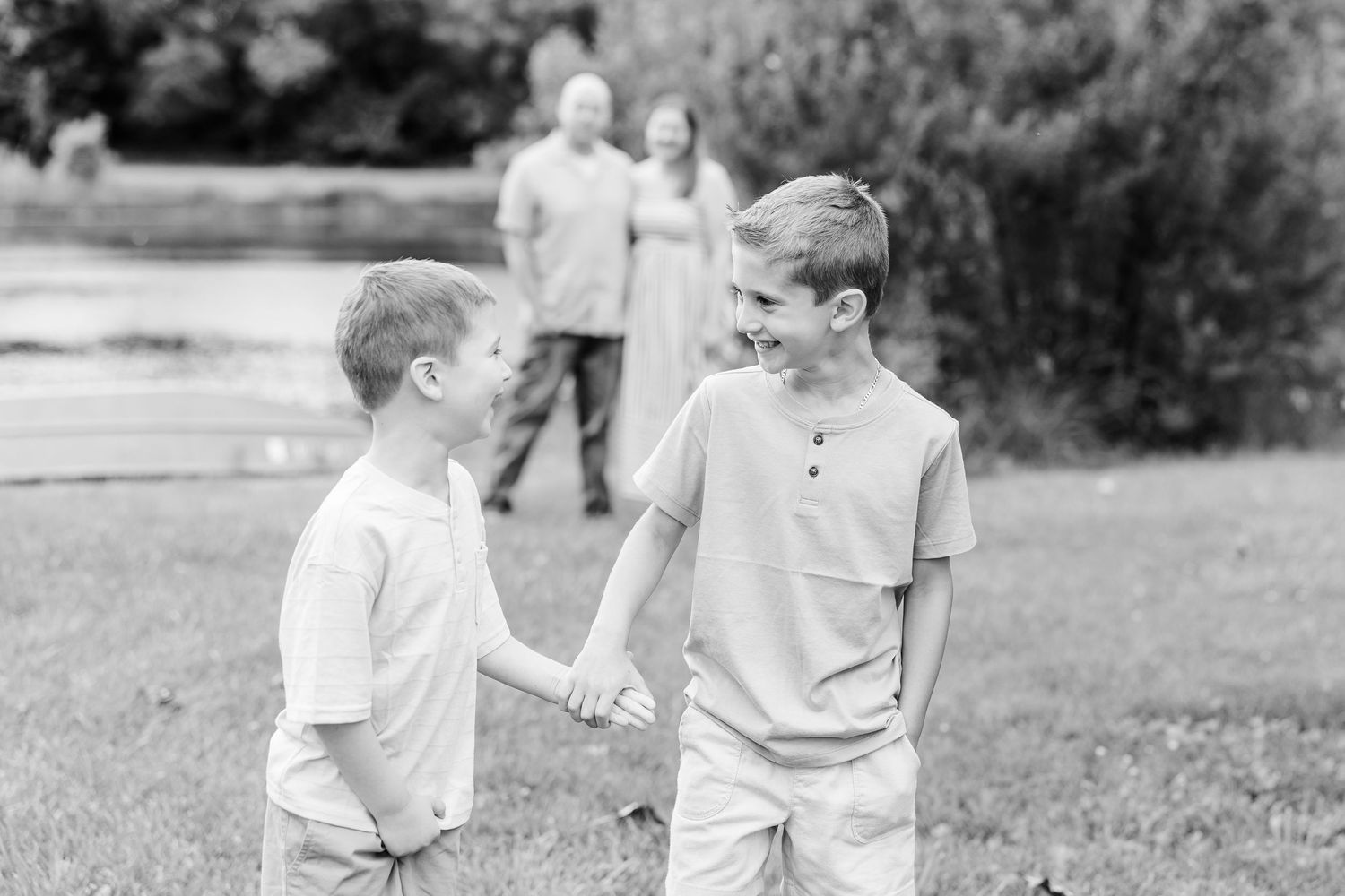 Black and white photo of two brothers holding hands during a family session at Shamrock Hills Park in Crystal Lake.