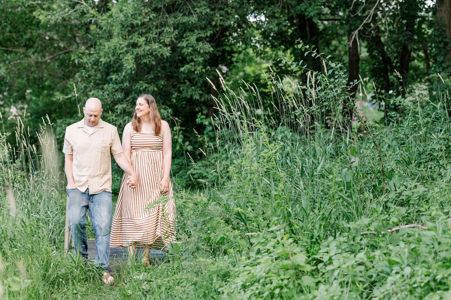 Mom and dad standing together in the greenery during a relaxed family photo session in Crystal Lake, Illinois.