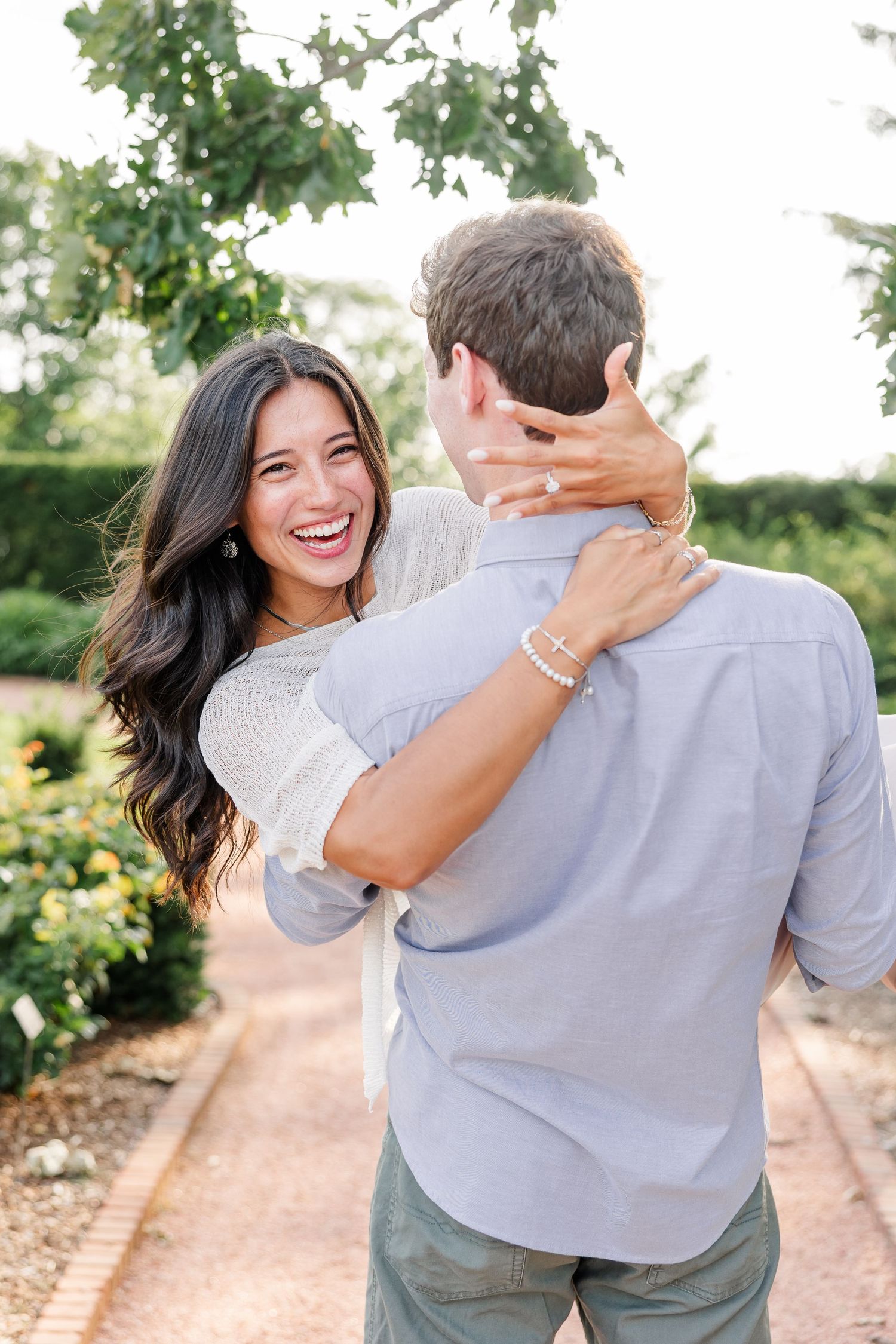 Alysia laughs as Jack carries her during their just-engaged portraits at Cantigny Park.