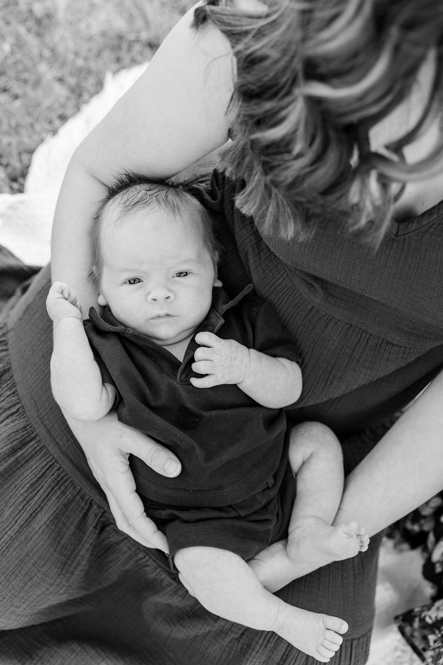 Black-and-white portrait of newborn Lincoln resting comfortably in his mother Hilary’s arms.