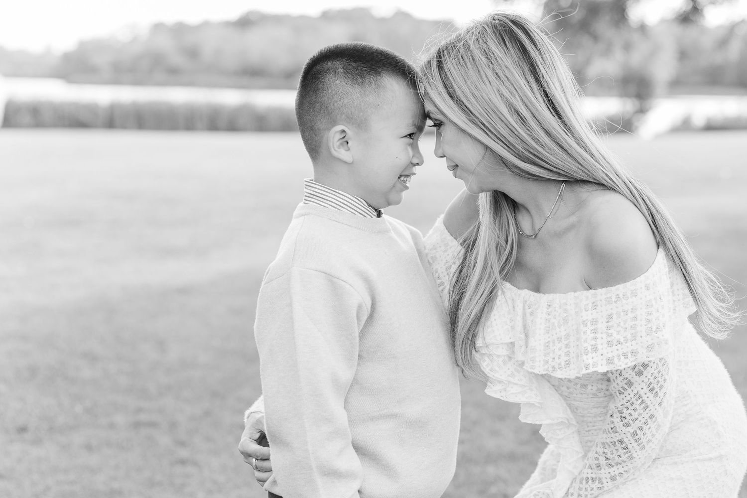 A tender black and white moment captured between parent and child outdoors in a natural setting. Busse Woods