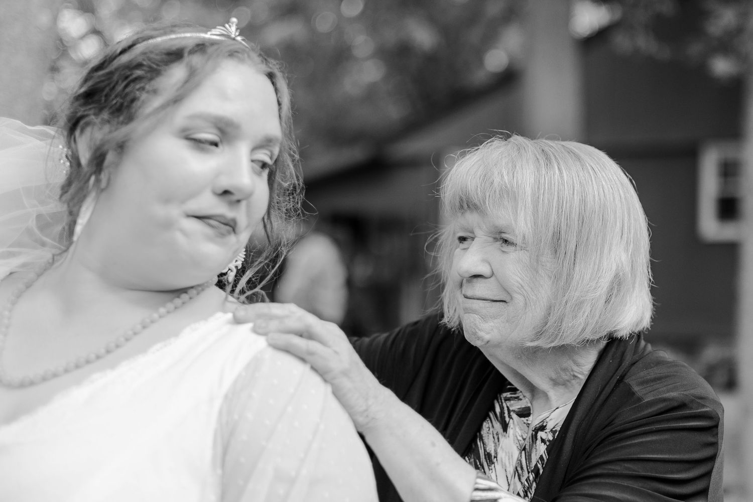 Two people share an intimate black and white moment during a wedding celebration.