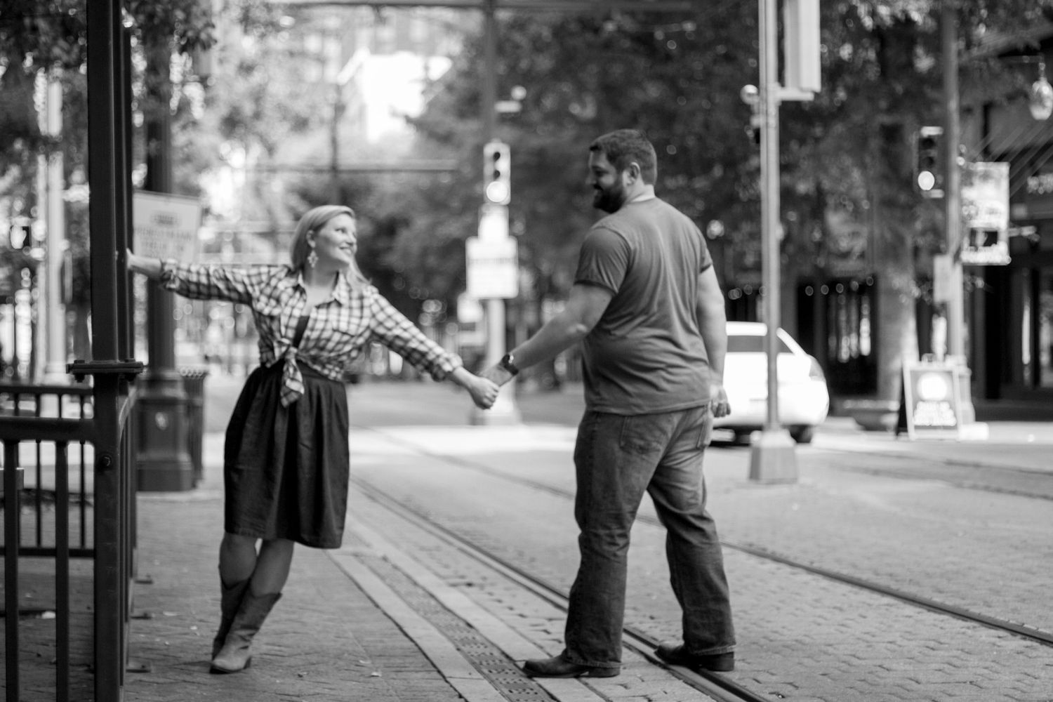 Black and white street portrait showing playful interaction between couple.