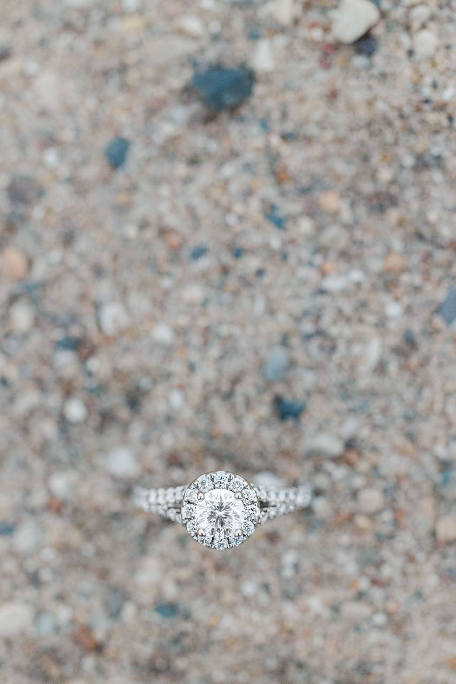 close up of Elizabeth's engagement ring in the sand on North Avenue Beach in Chicago