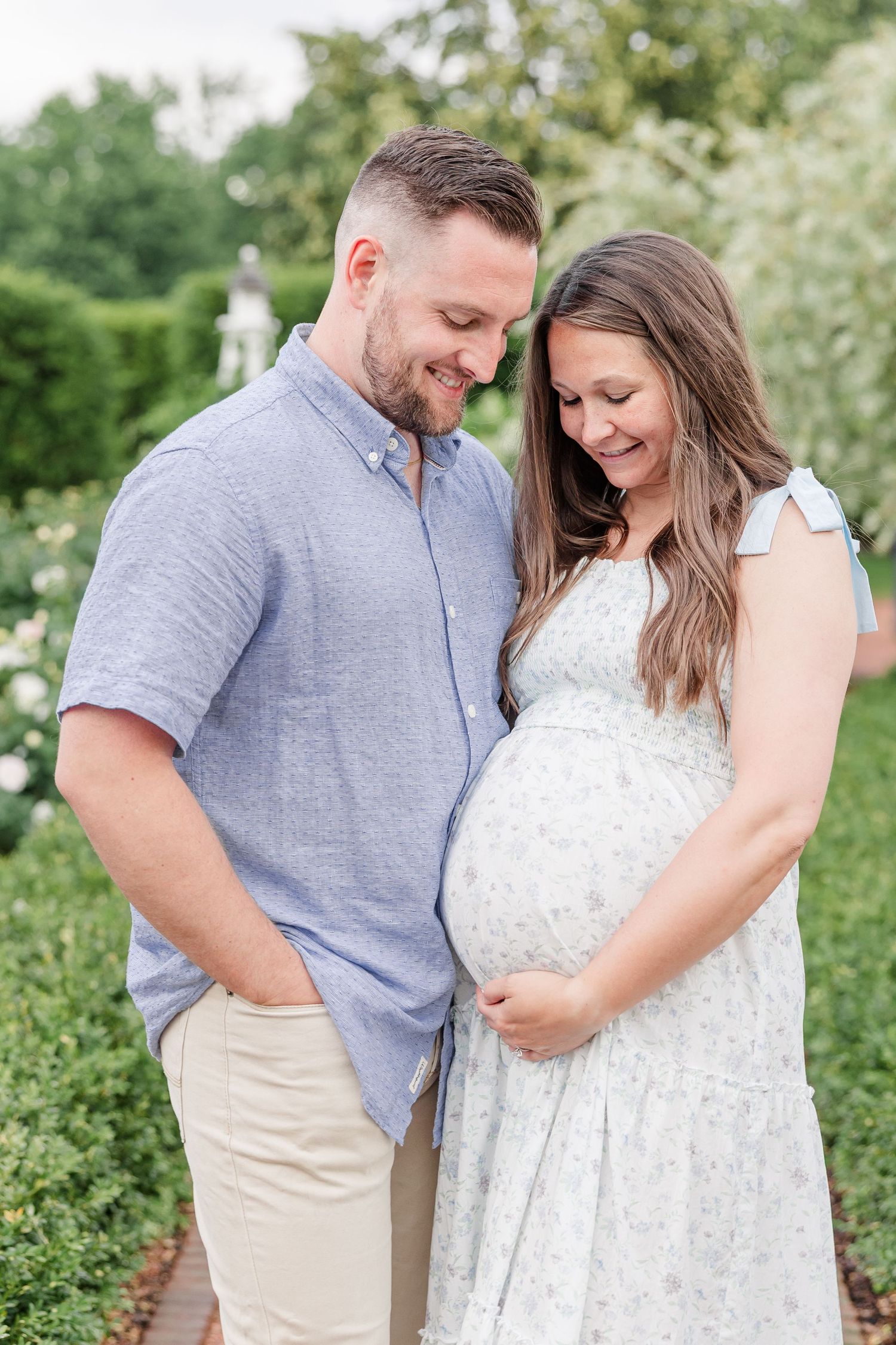 Expecting parents looking down at baby bump during a sweet maternity session in Wheaton
