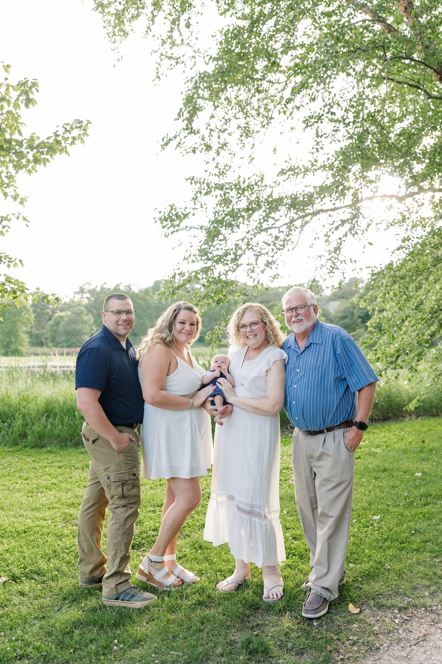 Extended family smiling together in summer greenery at Veterans Acres Nature Center during a Crystal Lake family session