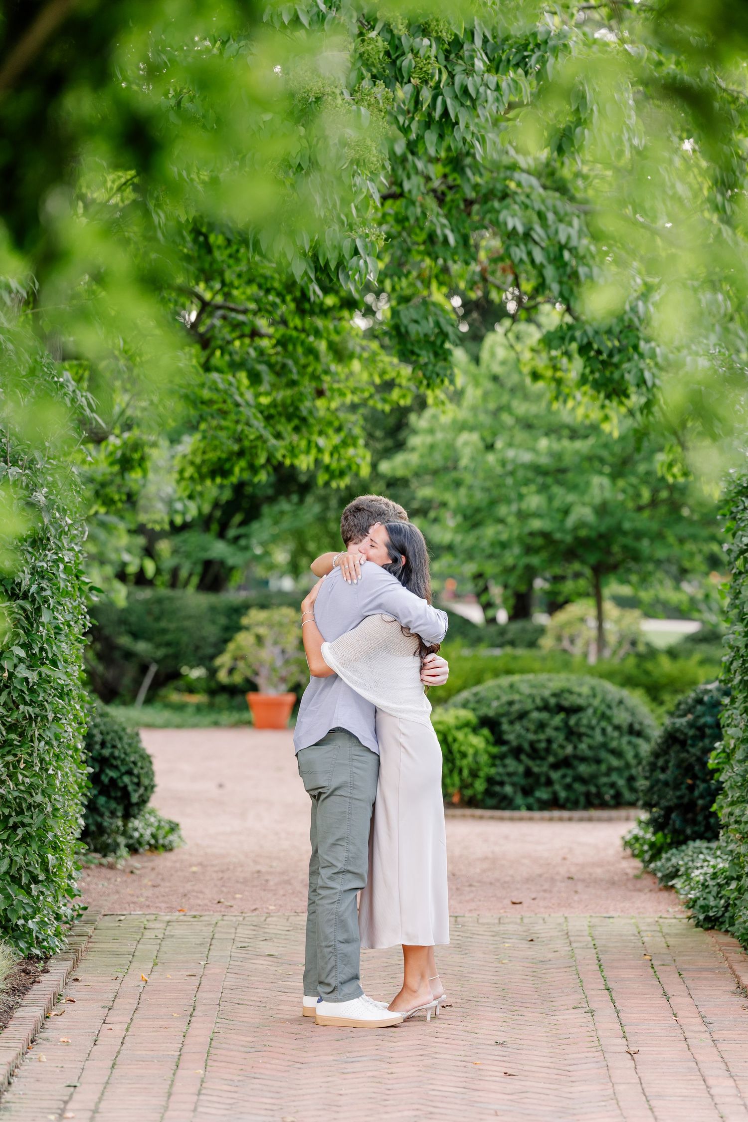 Newly engaged Alysia and Jack share a joyful hug in the Octagon Garden.