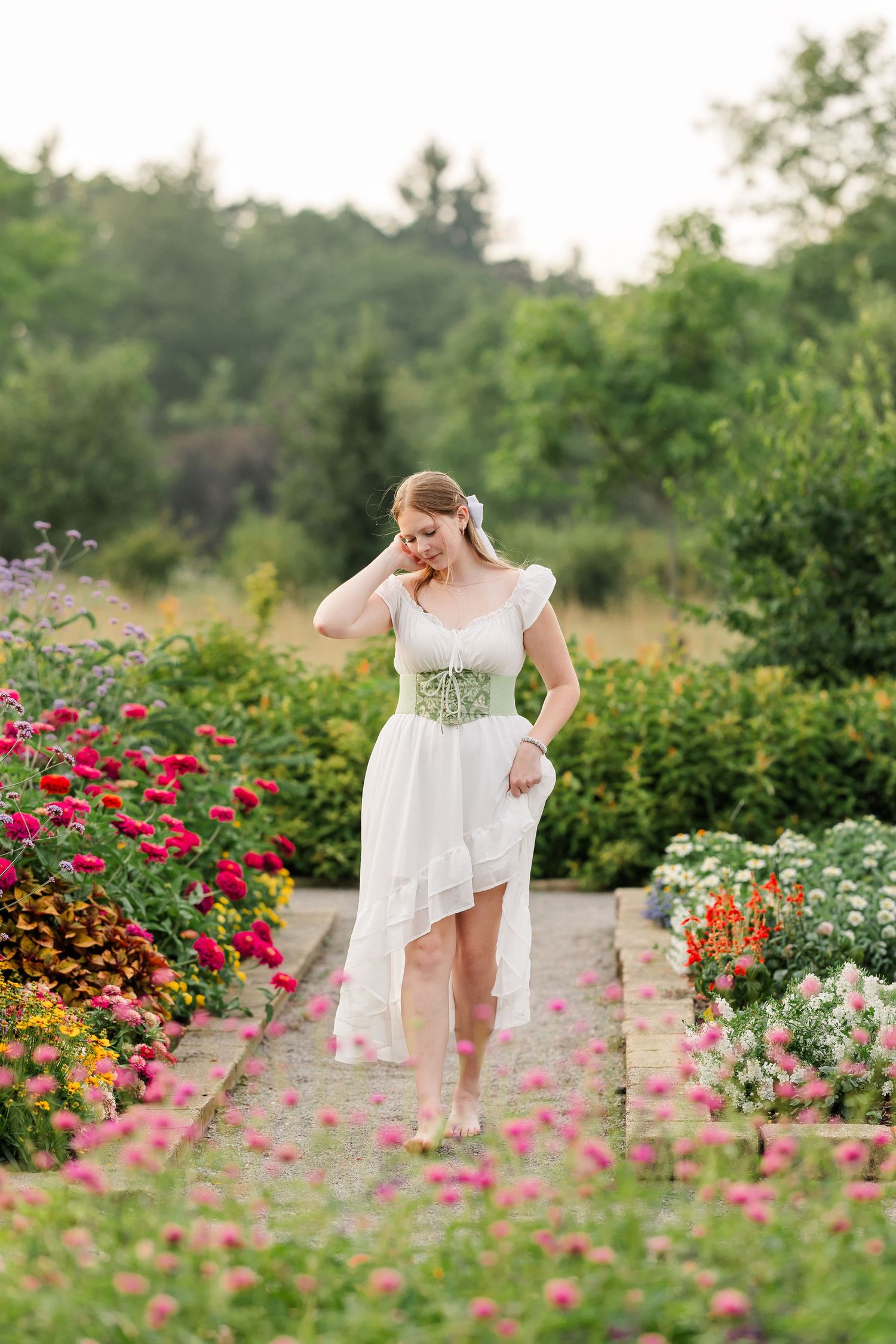 Bartlett High School senior walks among vibrant summer flowers during her Cantigny Park portrait session.