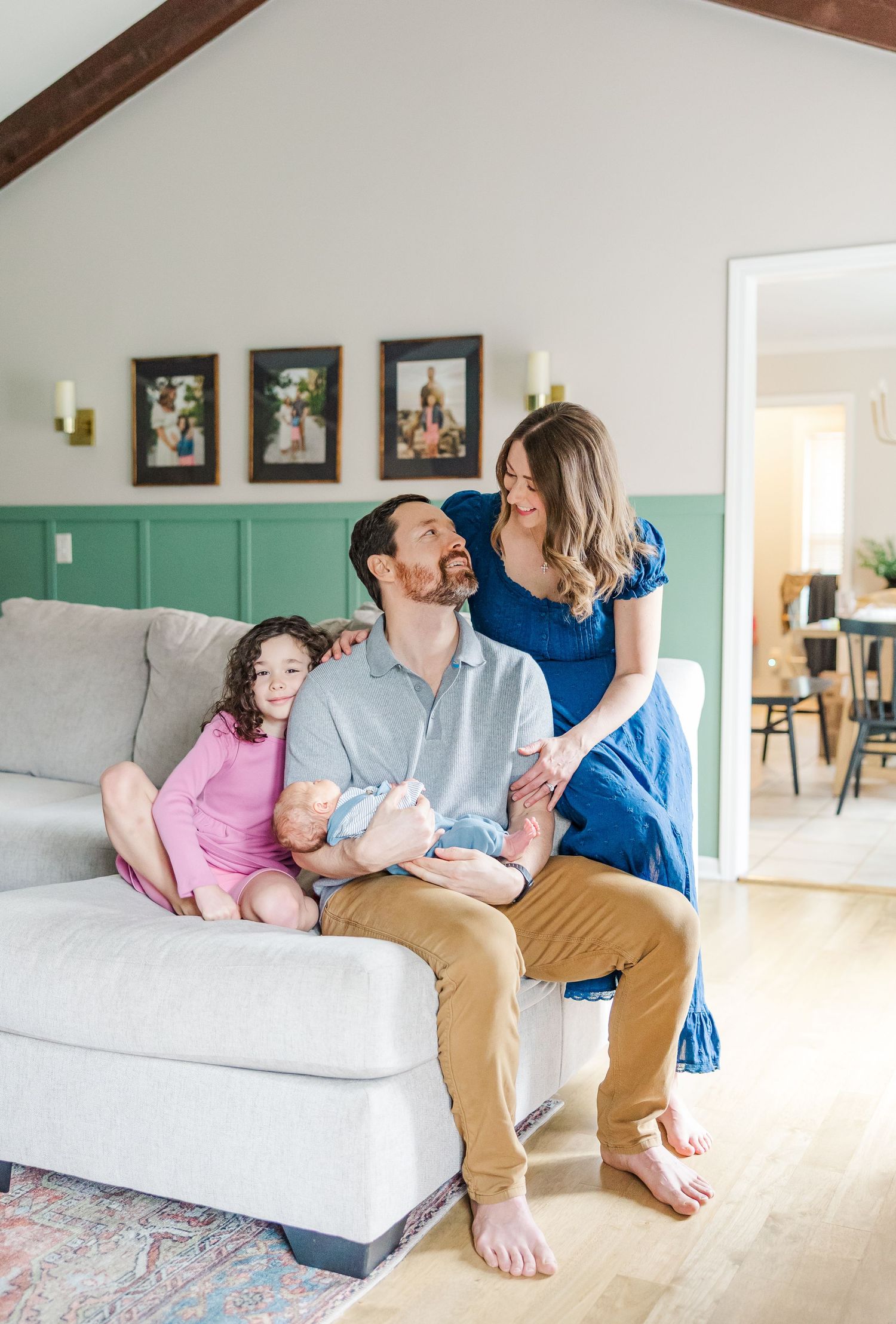 Family of four sitting together during bright in-home lifestyle newborn session in Crystal Lake, Illinois