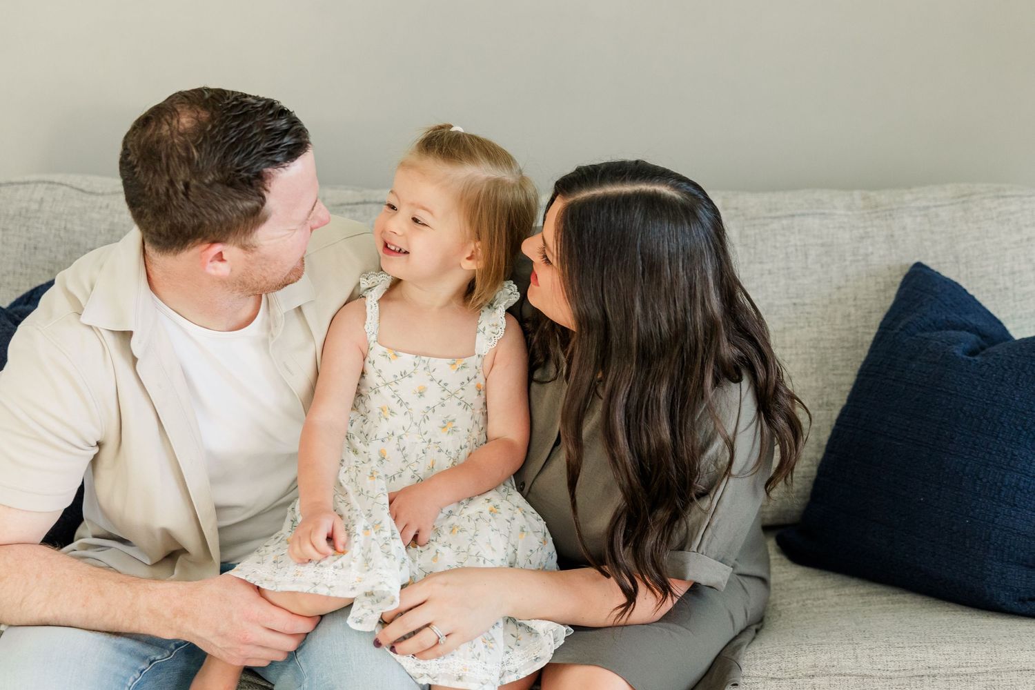 Parents kissing their little girl during a cozy in-home lifestyle newborn session in Huntley IL