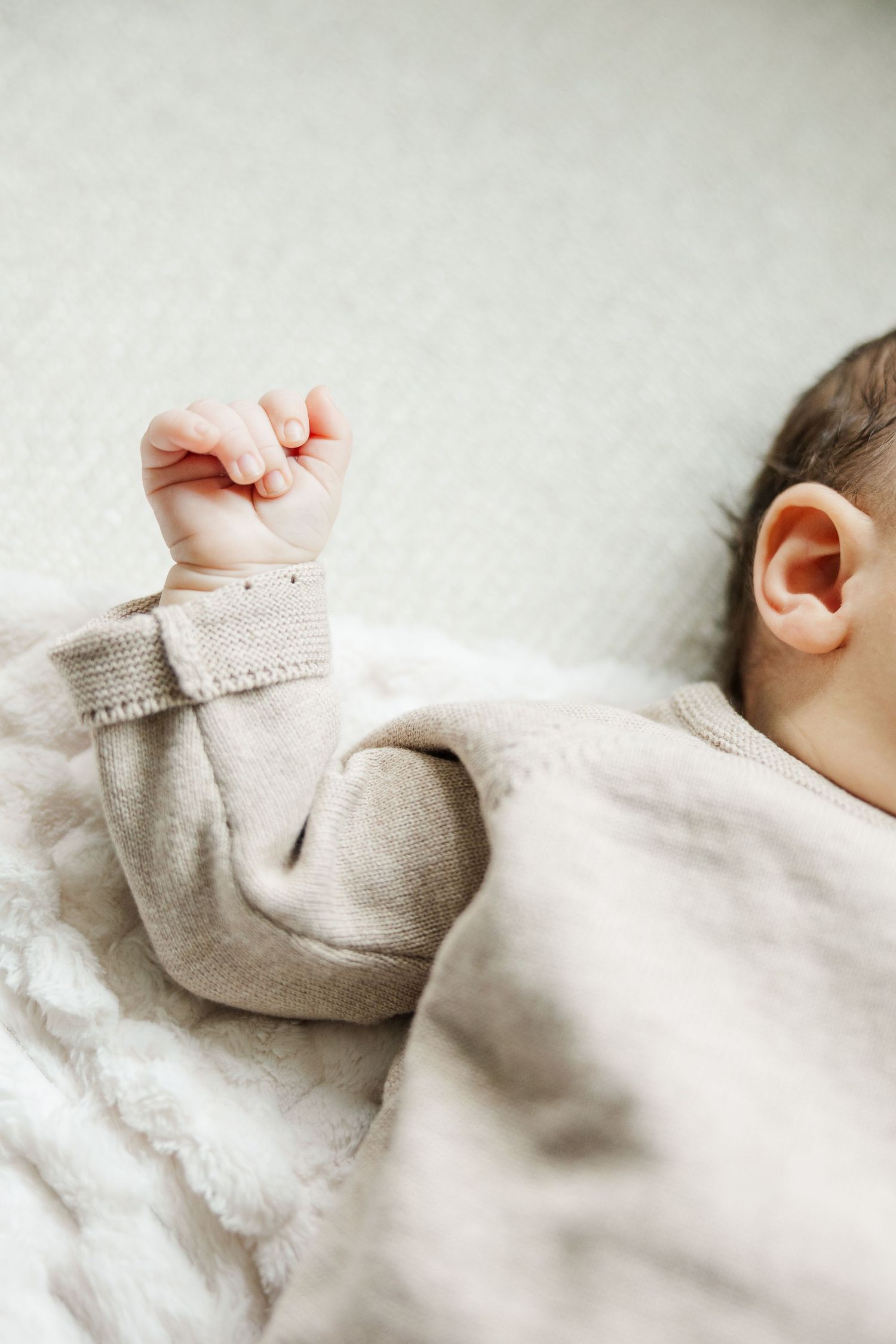 Lifestyle newborn photography detail of tiny baby hand during an in-home newborn session in Palatine Illinois