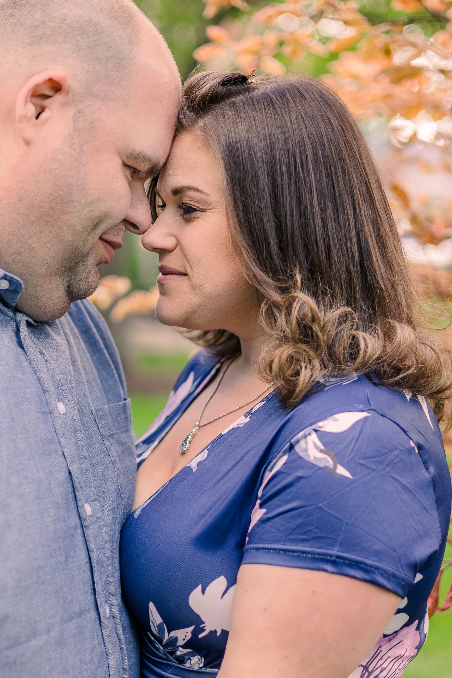 Romantic outdoor portrait in autumn with fall foliage in background.