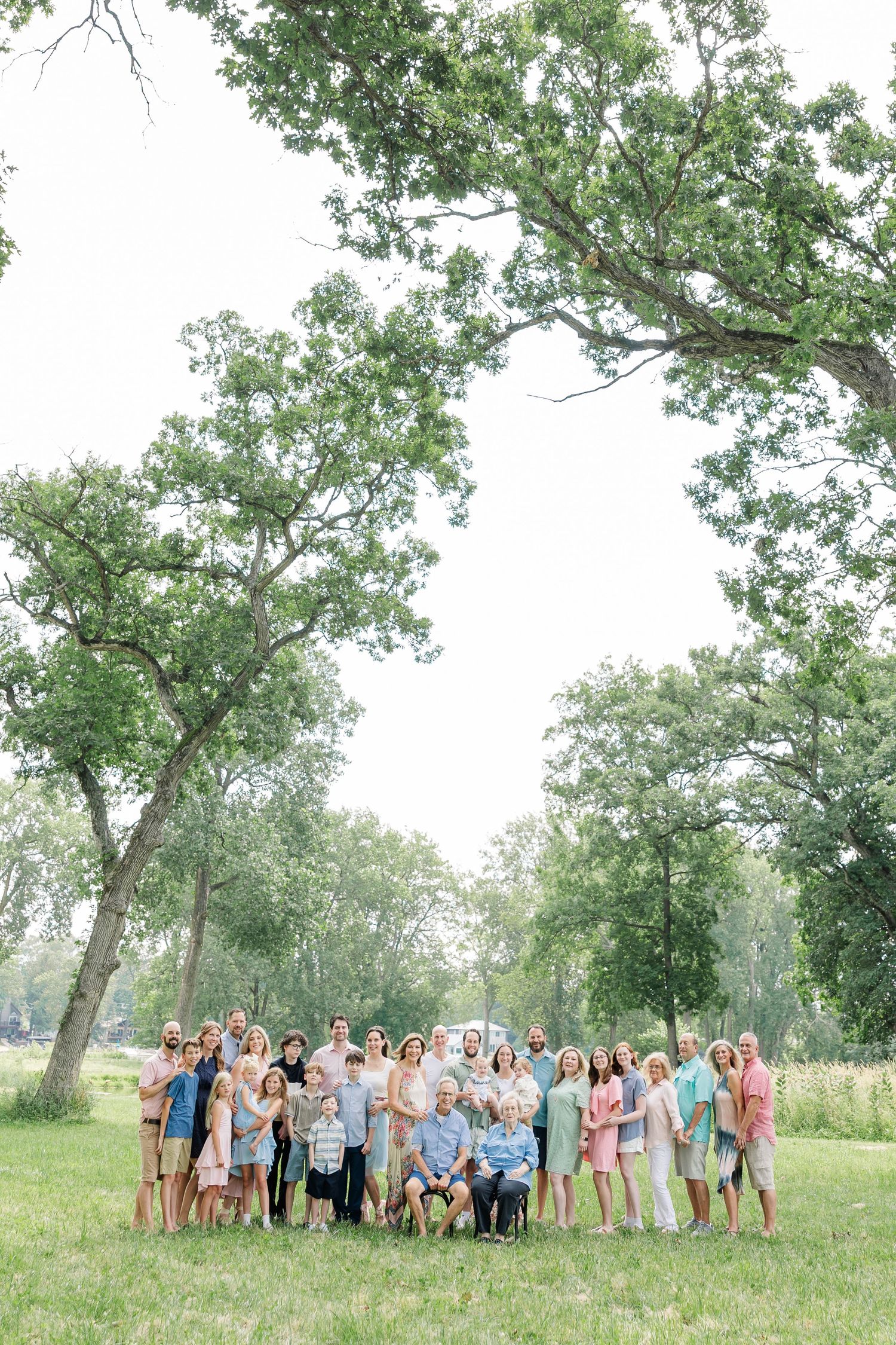 Extended family gathered under tall trees for summer reunion photos in Crystal Lake, Illinois.