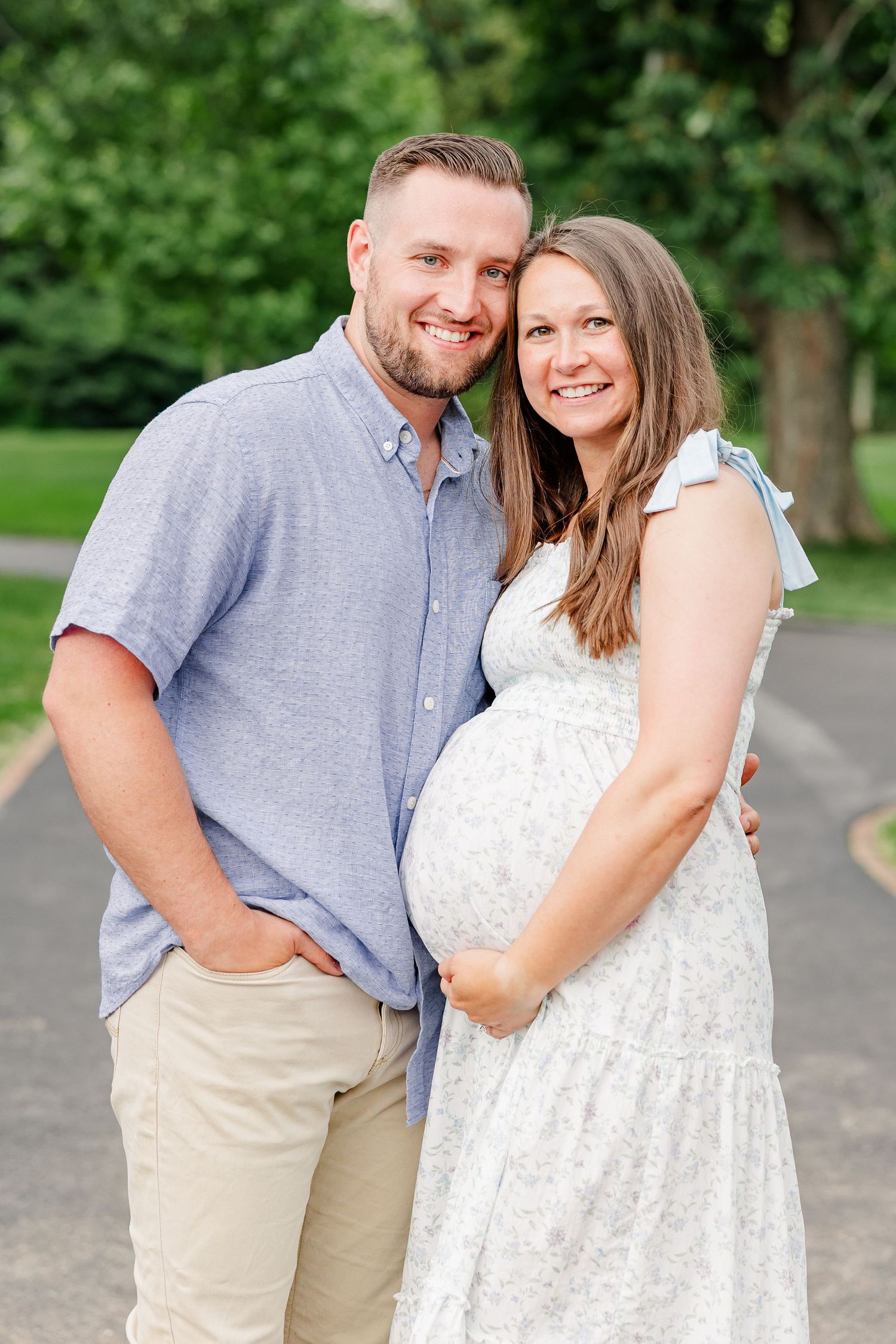 Expecting parents smiling together during a classic garden maternity portrait