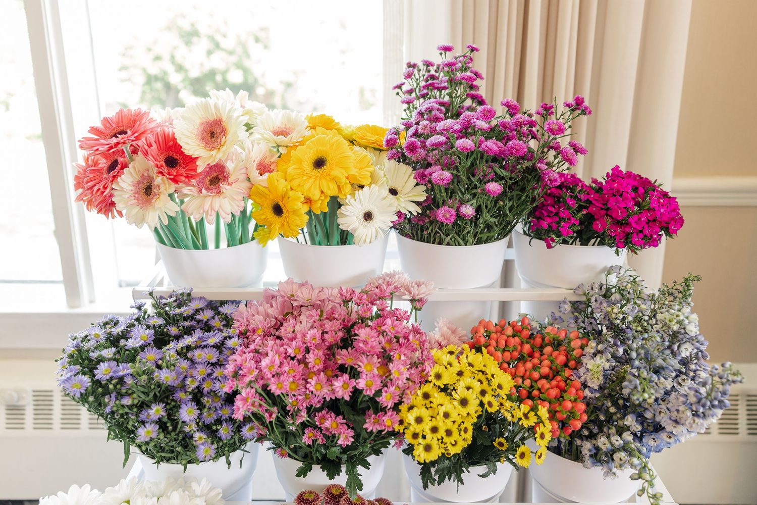 Tiered floral display with colorful wildflower bouquets at bridal shower