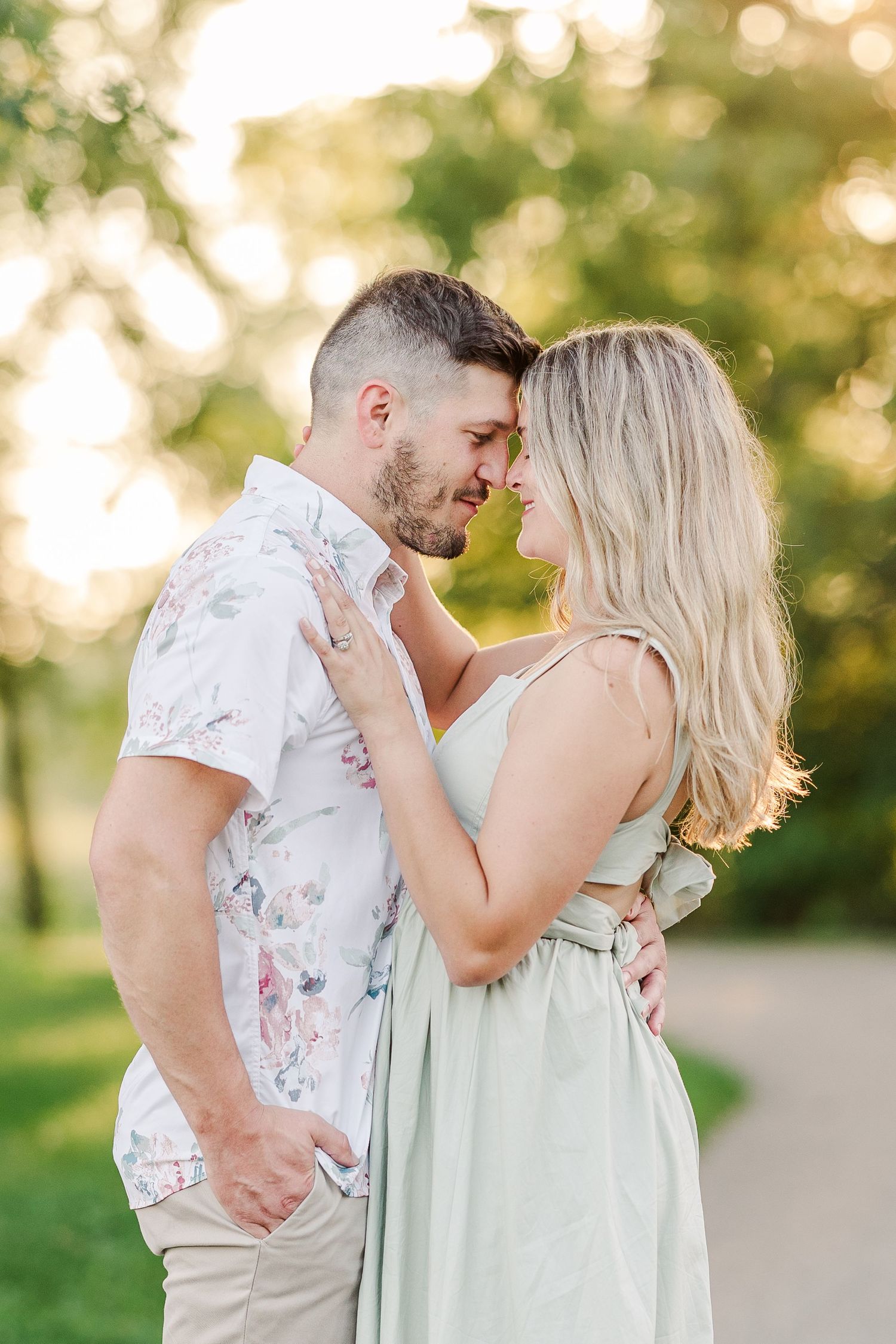 An intimate moment between a couple in coordinated outfits on a sunlit path.
