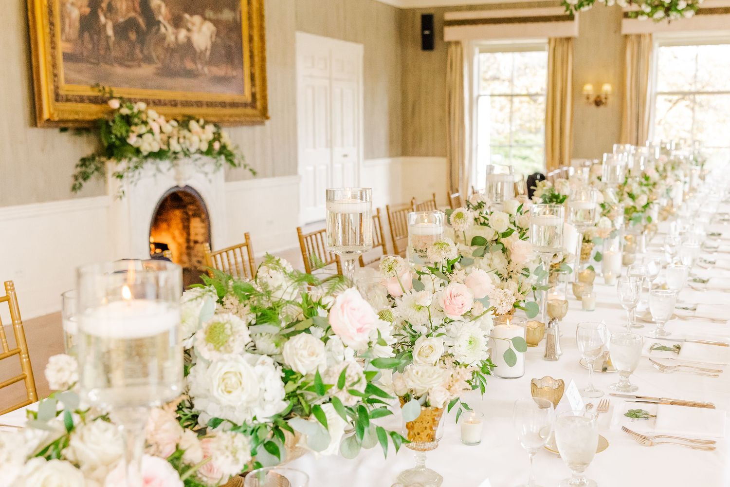 Elegant dining room with long tables, white floral arrangements, and classic decor.
