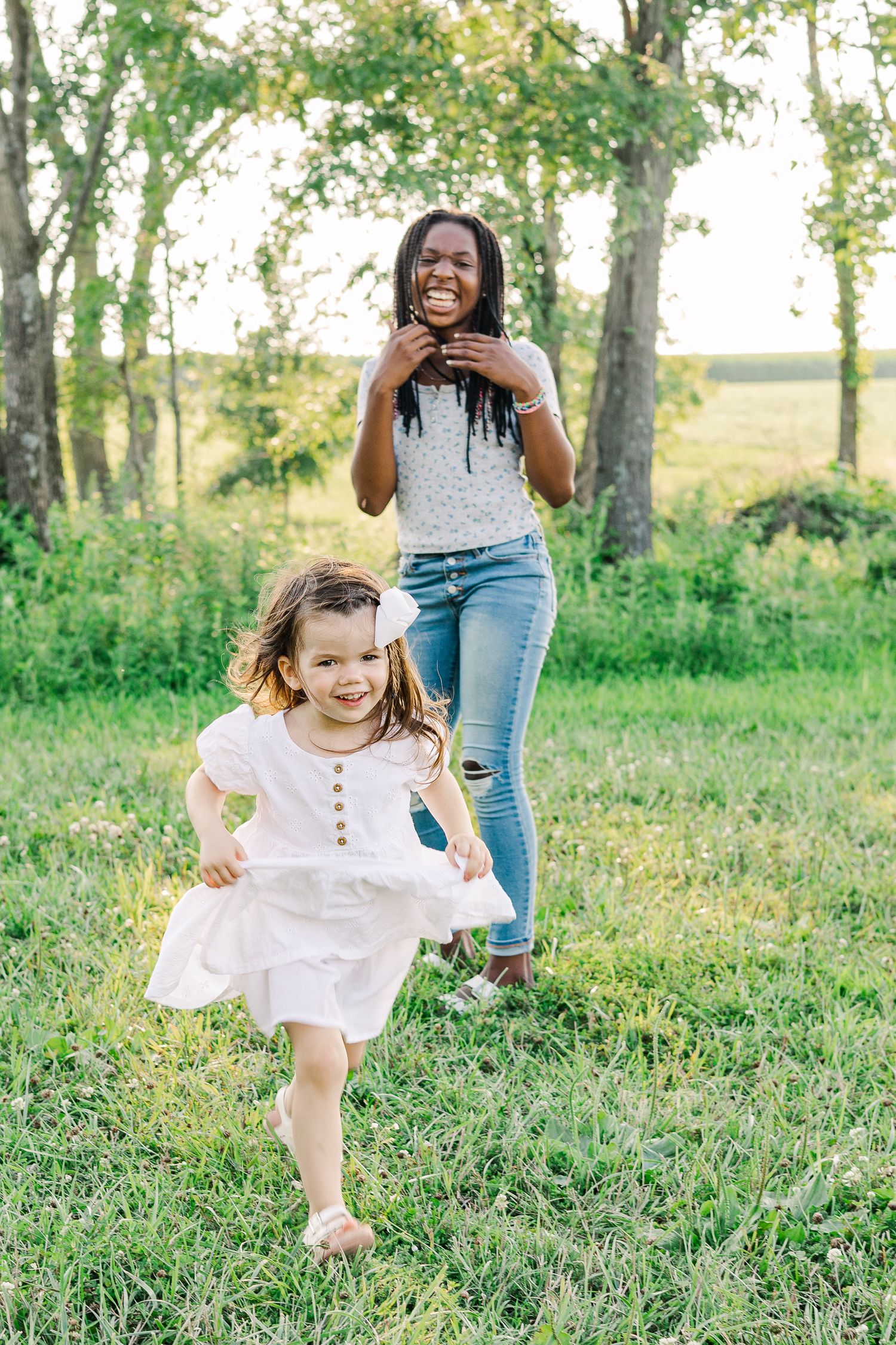 Two people enjoying a playful moment running through a lush green field.