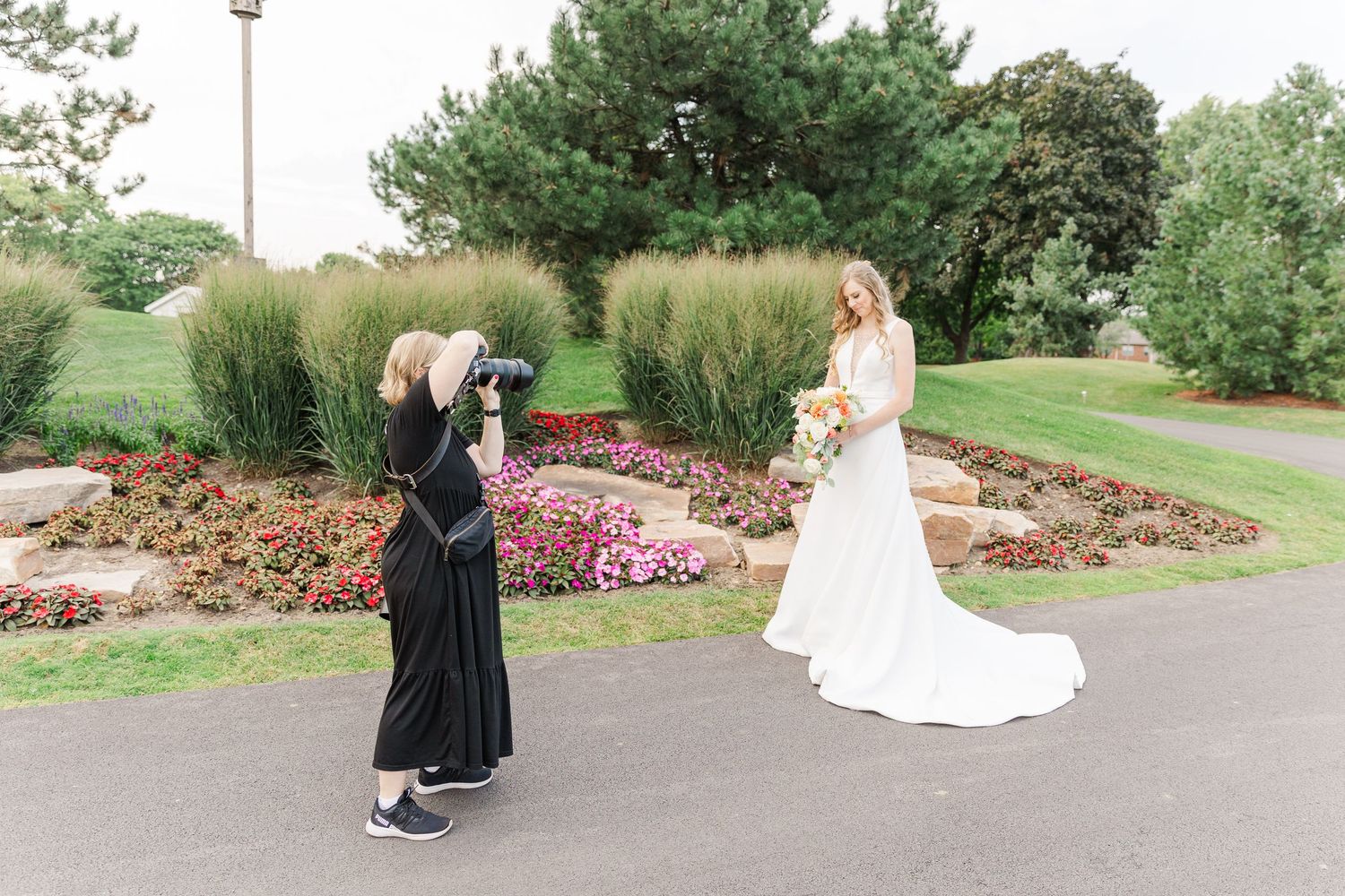 Cassie Lacina photographing a bride outdoors in a garden setting