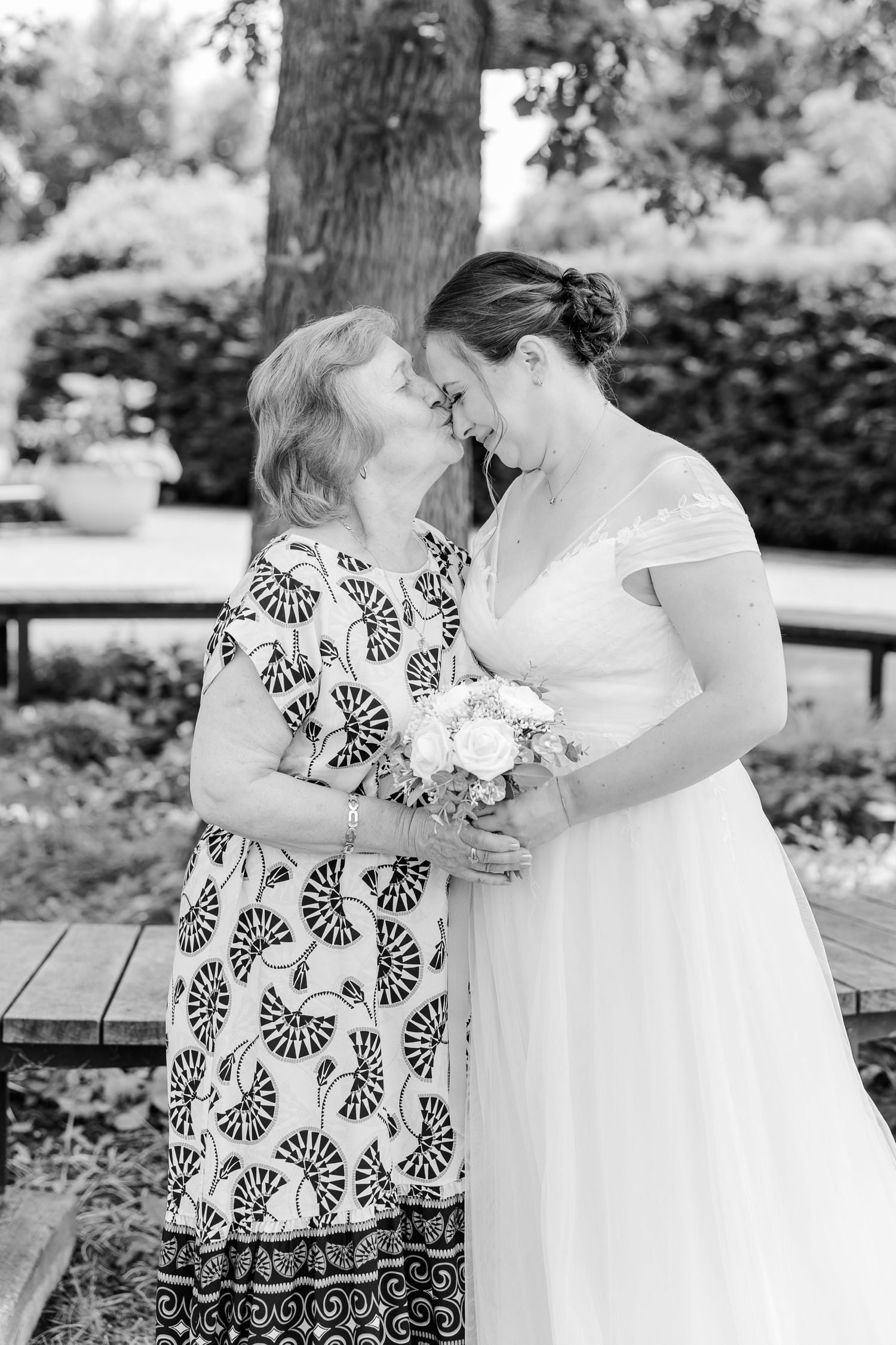 Black-and-white portrait of the bride hugging a family member after her courthouse wedding.