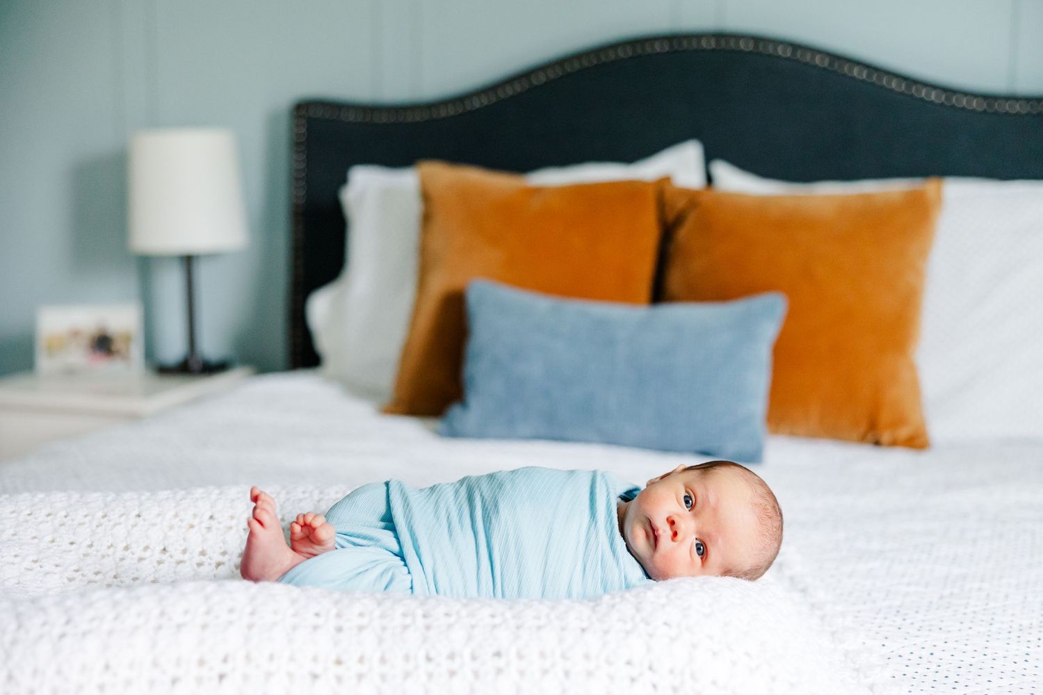 Newborn baby boy lying on bed during in-home lifestyle newborn session in Crystal Lake, Illinois