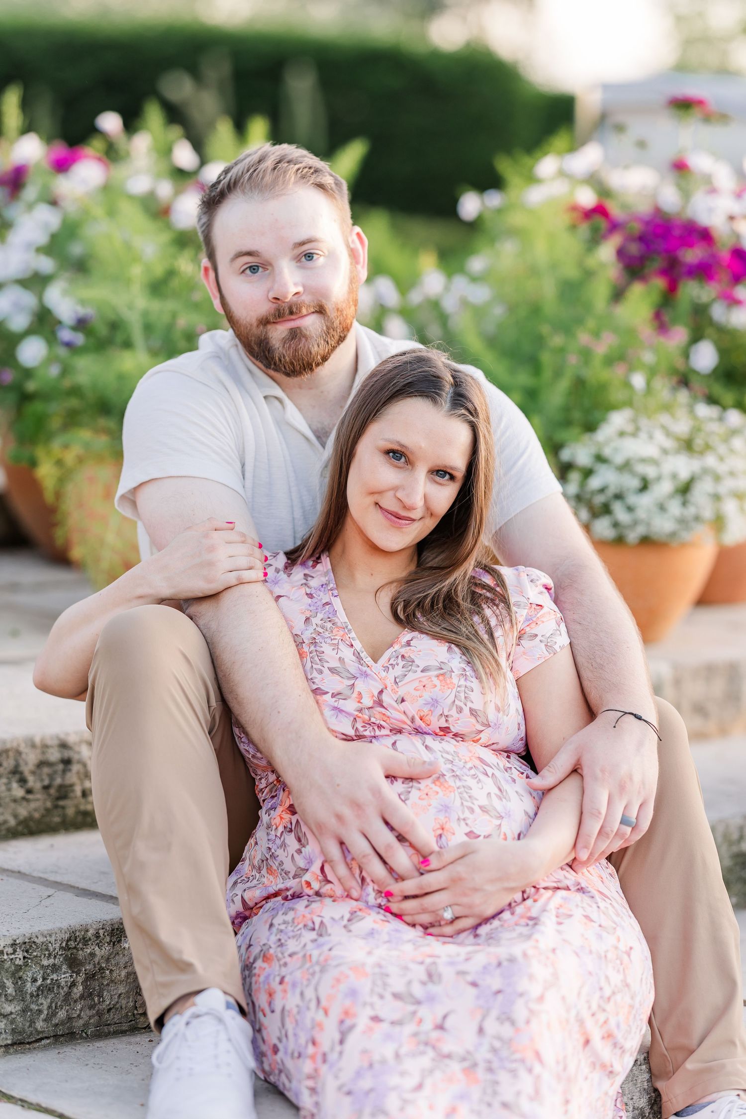 Seated maternity portrait of expecting parents on garden steps at Cantigny Park in Wheaton Illinois