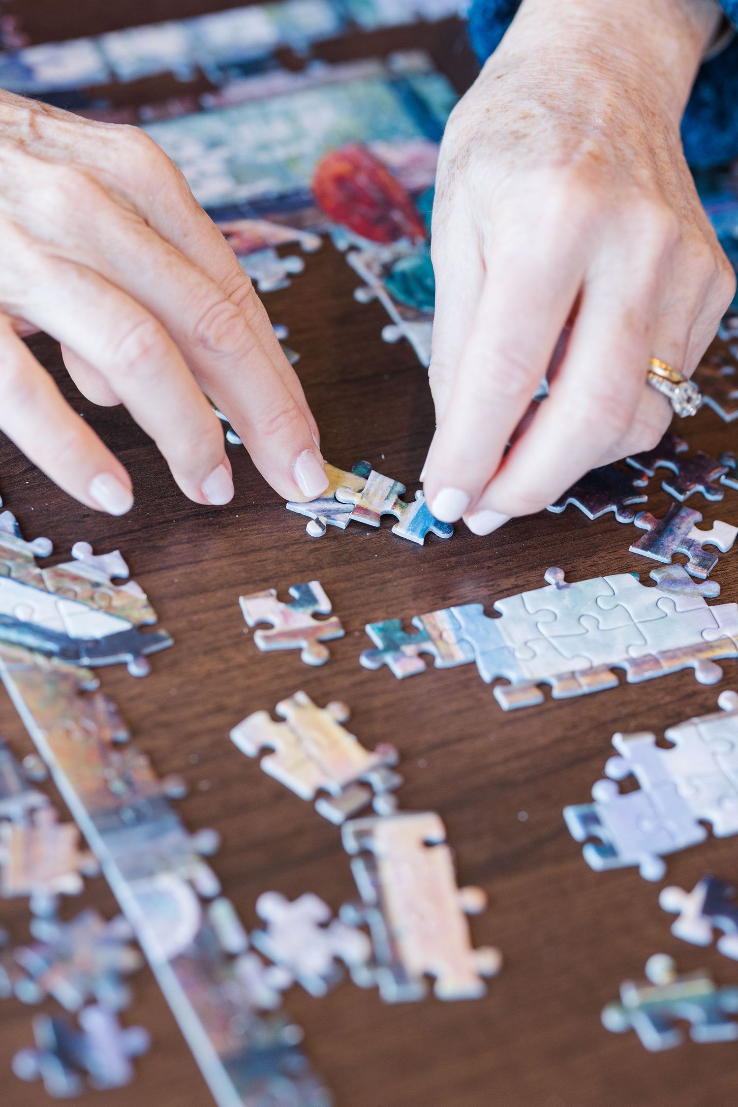 Beacon Hill senior living branding photo in Lombard, Illinois featuring hands placing puzzle pieces