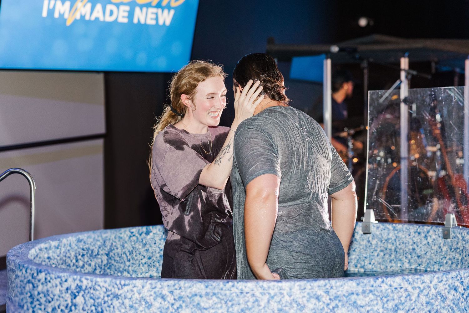 Woman praying with another attendee during baptism at The Chapel in McHenry