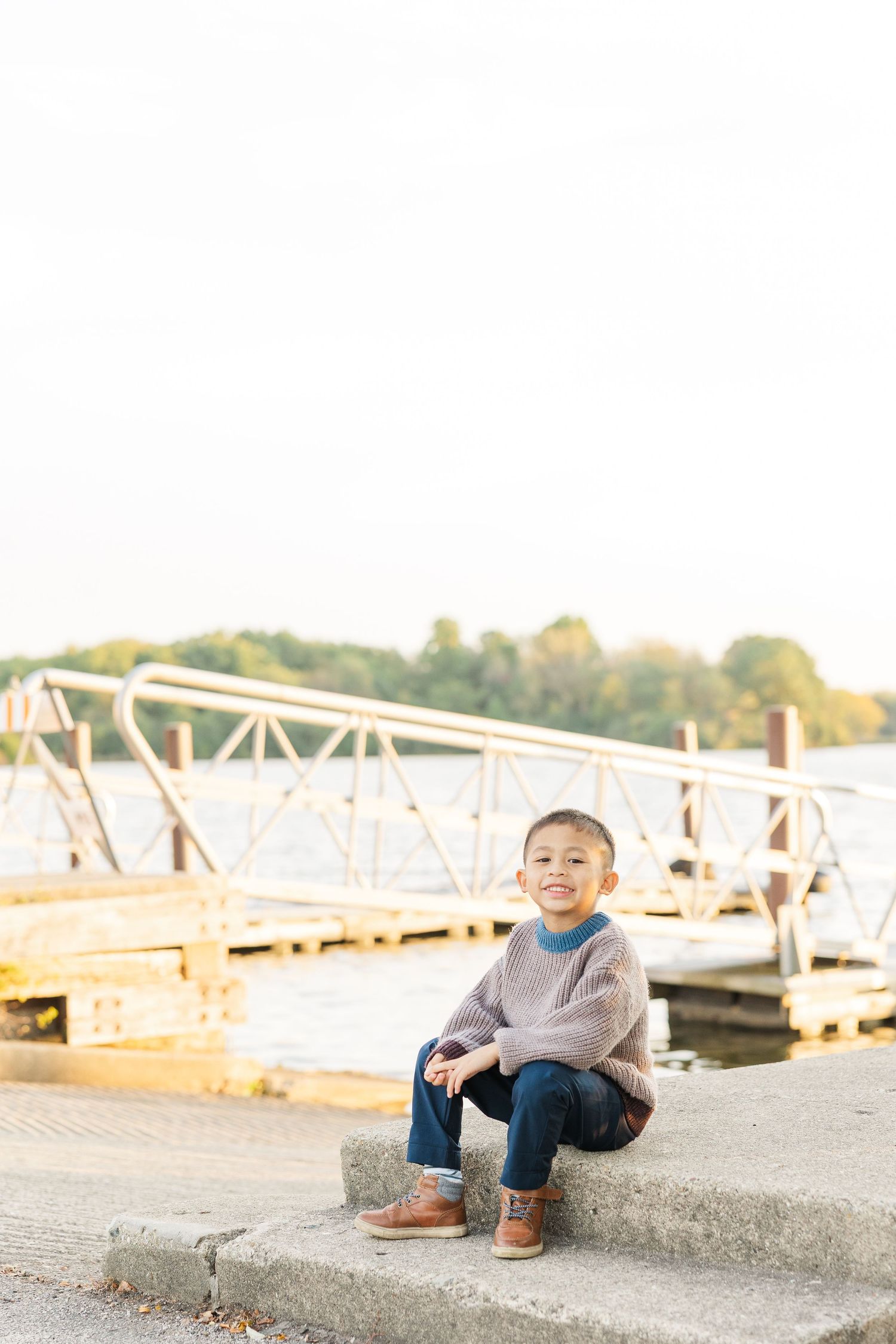 A child lays on a wooden bridge walkway on a sunny autumn day. Busse Woods