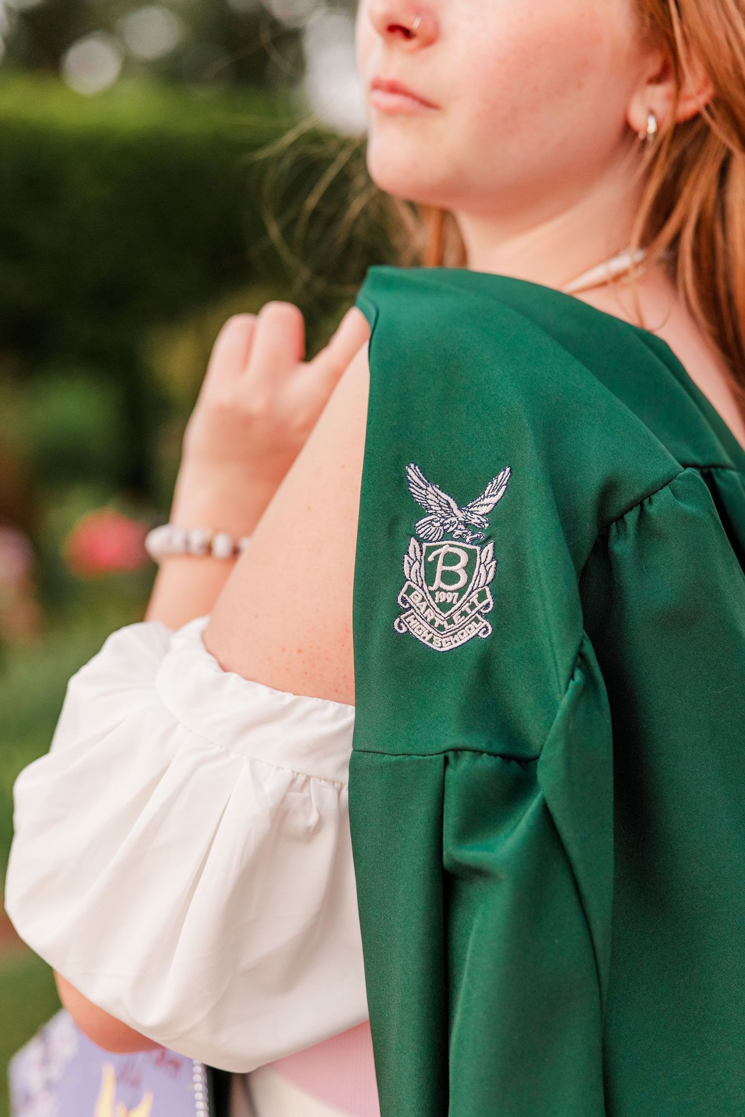 Detail of Samantha wearing her green Bartlett High School graduation gown during her Class of 2027 senior session.