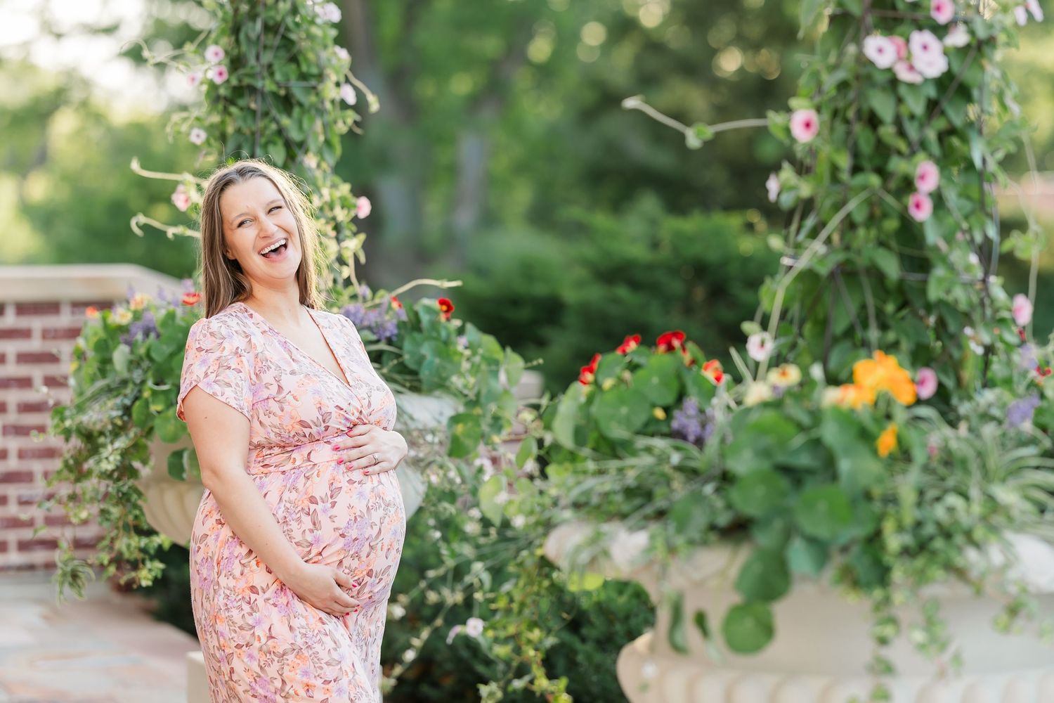 Expecting mother smiling in the Cantigny gardens during a summer maternity session in Wheaton Illinois