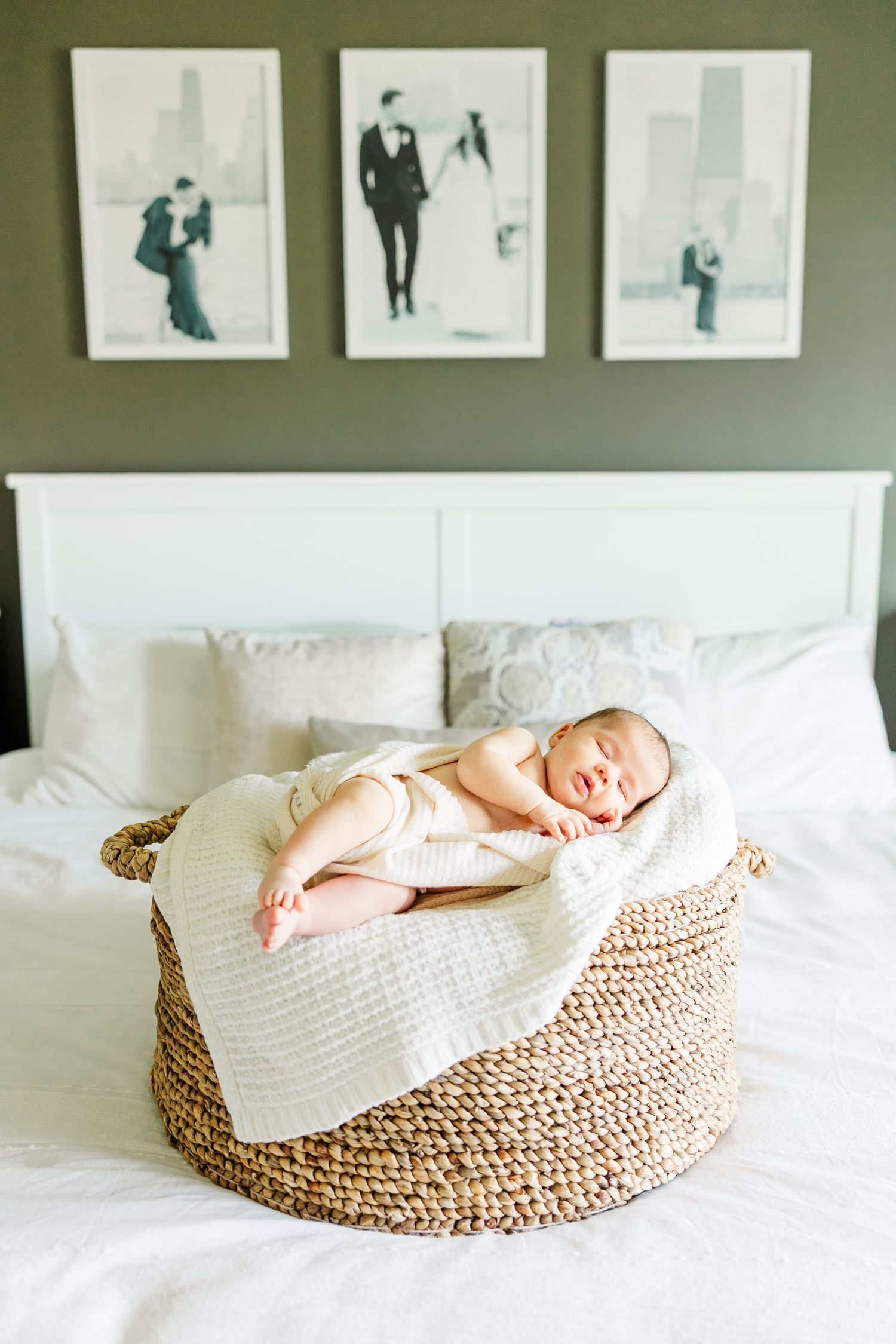 Newborn baby girl sleeping in a basket on the bed during an in-home lifestyle newborn session in Huntley IL