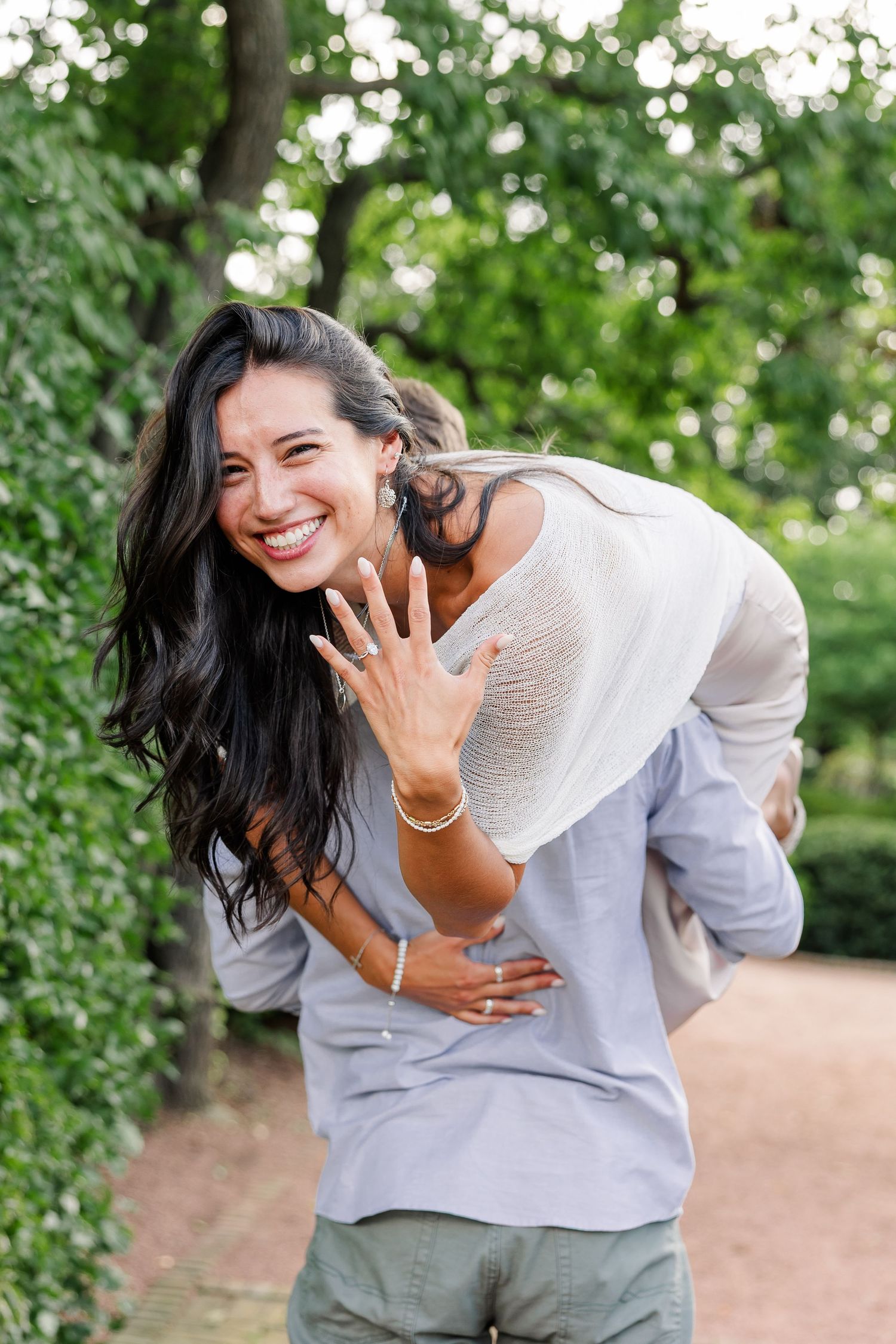 Alysia shows her new engagement ring while riding on Jack’s back and laughing.