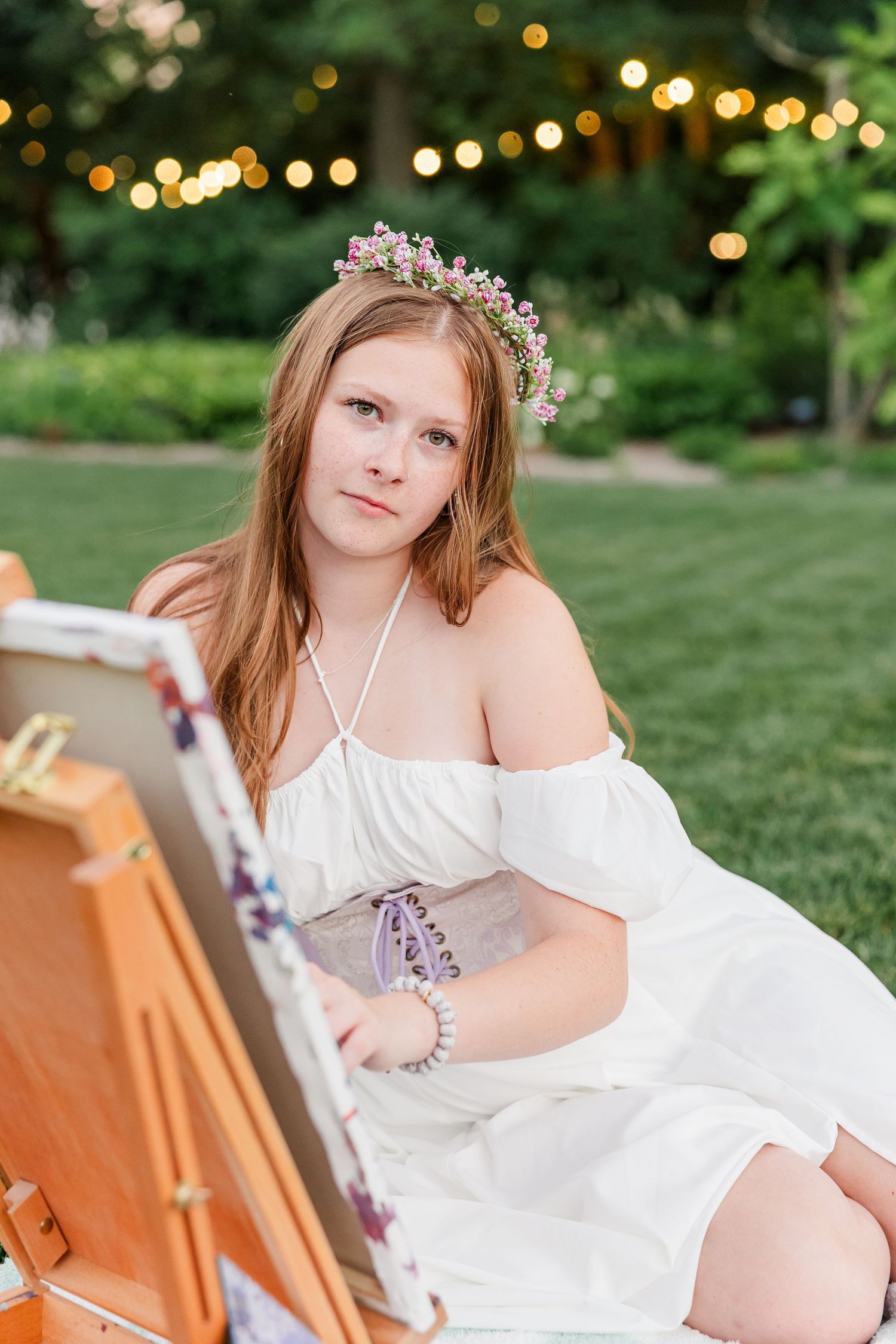 Samantha wears a flower crown while painting outdoors during her creative Cantigny Park senior portraits.
