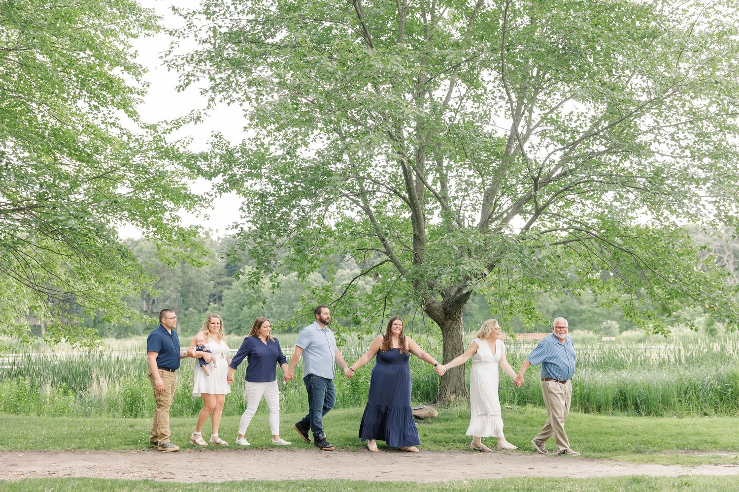 Extended family walking together on a tree-lined path at Veterans Acres Nature Center in Crystal Lake