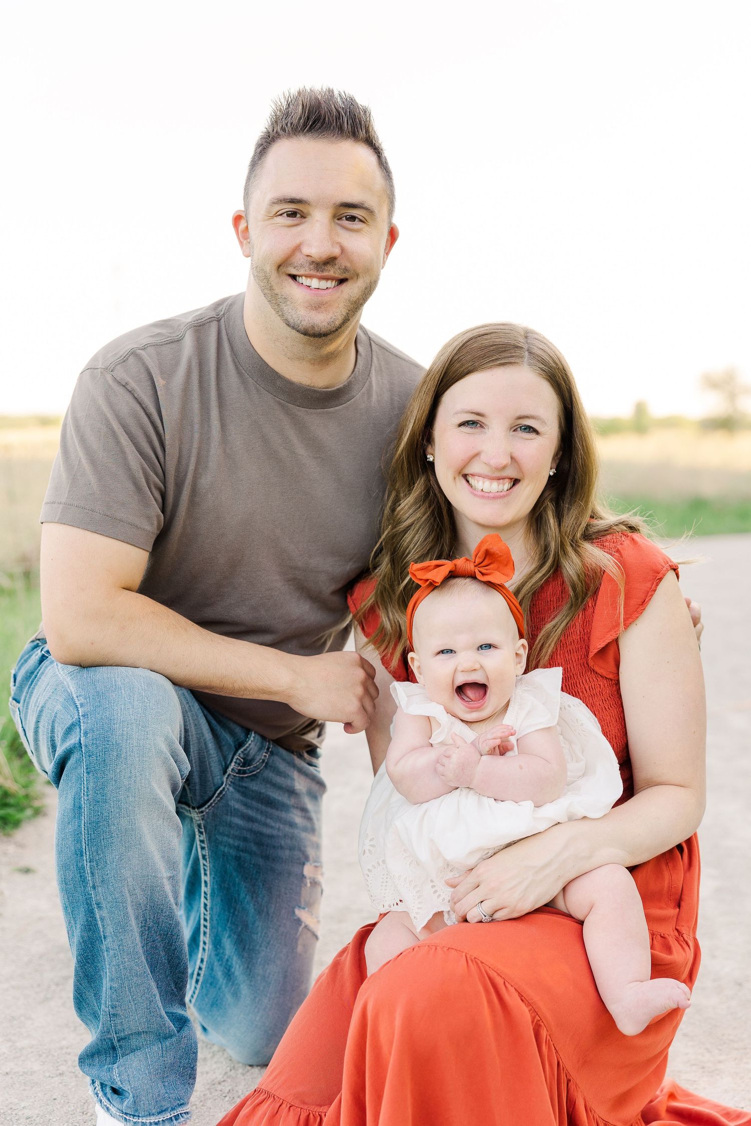 Outdoor family portrait with everyone smiling during golden hour.