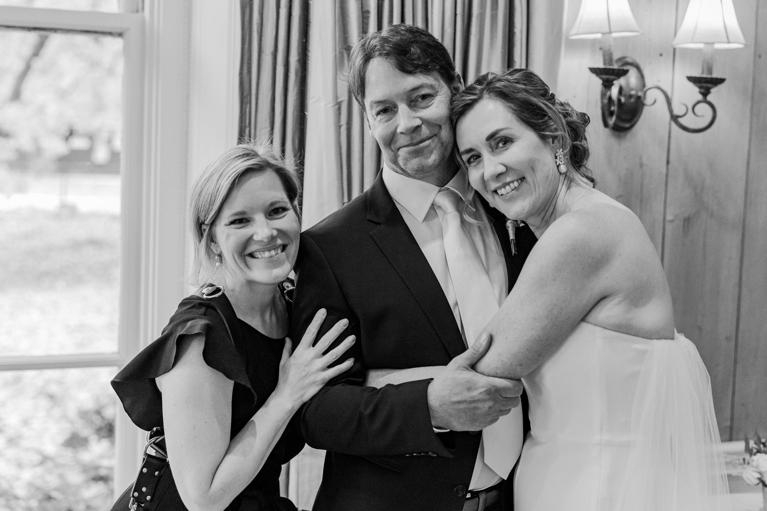 Black and white candid wedding photo showing joyful moment with guests.