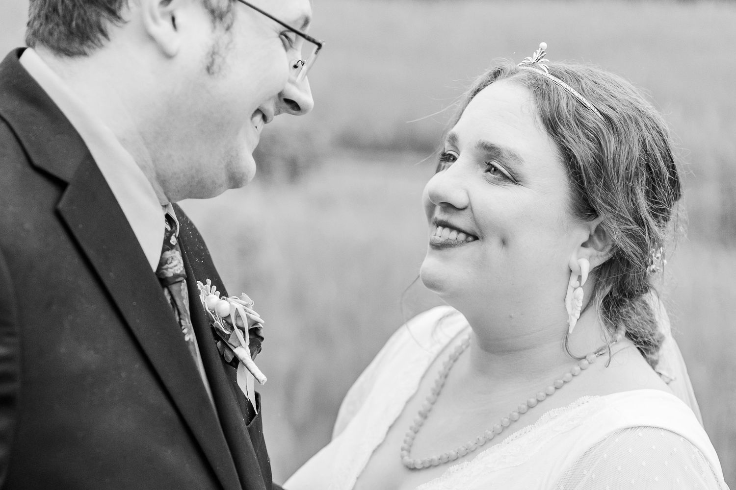 Black and white portrait of happy newlyweds sharing an intimate moment outdoors.