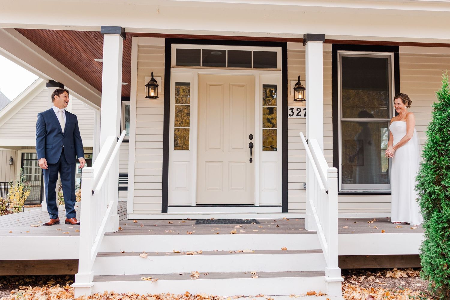 White front porch with classic door and outdoor lighting fixtures.