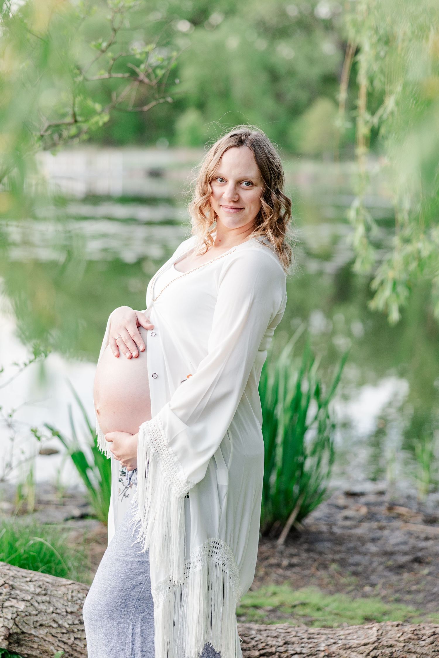 Mother holding baby bump during golden hour maternity photos at Veterans Acres in Crystal Lake.