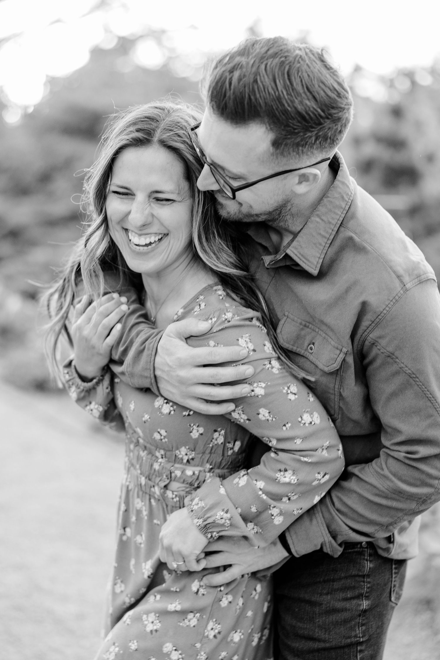 Black and white engagement portrait of a couple laughing together at Cantigny Park