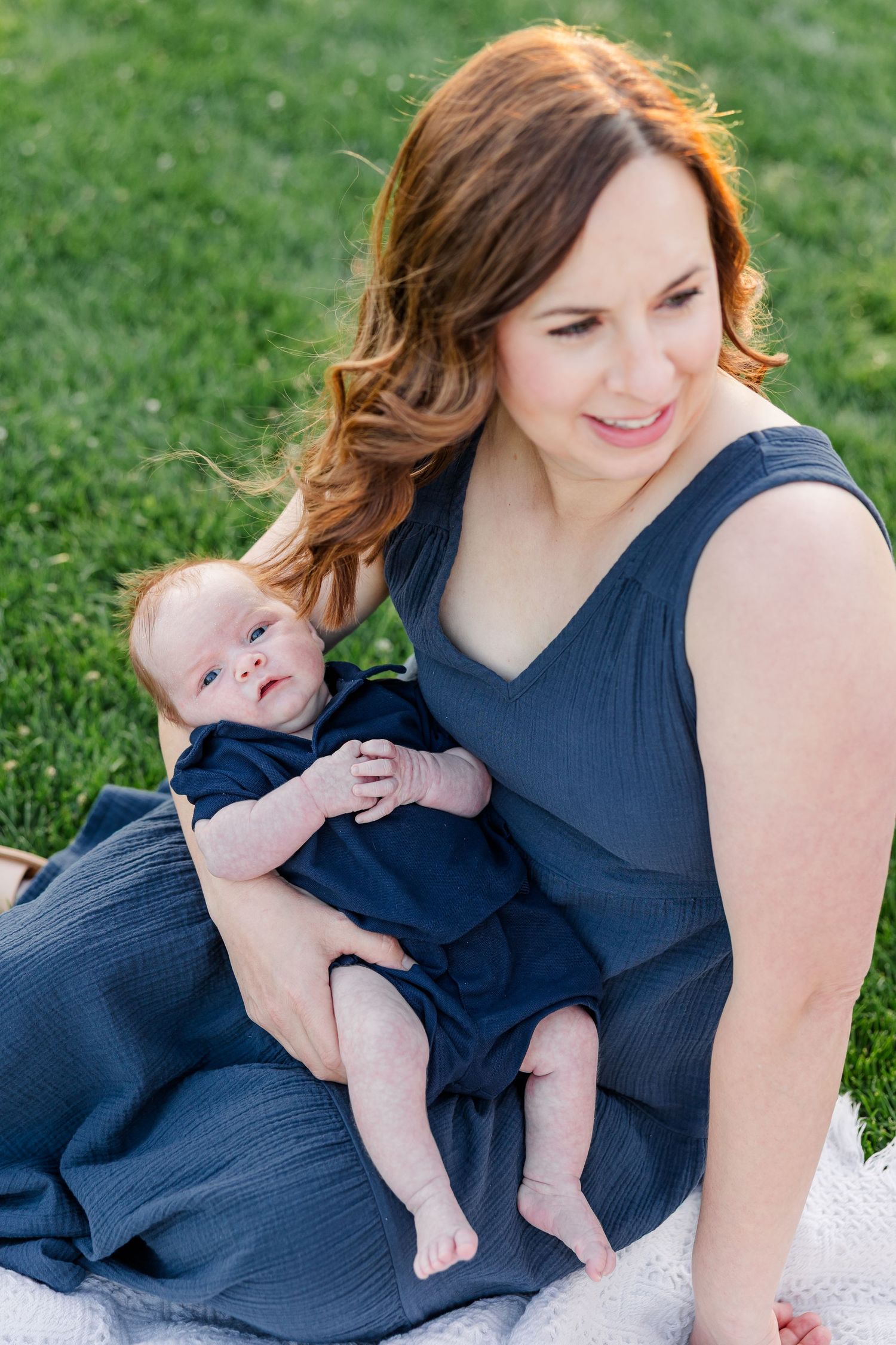 Hilary holding baby Lincoln during their warm summer evening family session at Cantigny Park.