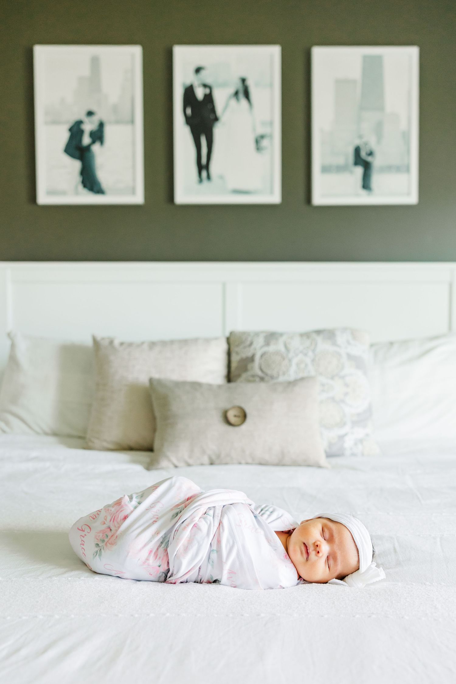 Swaddled newborn baby girl resting on a white bed during an in-home newborn session in Huntley IL
