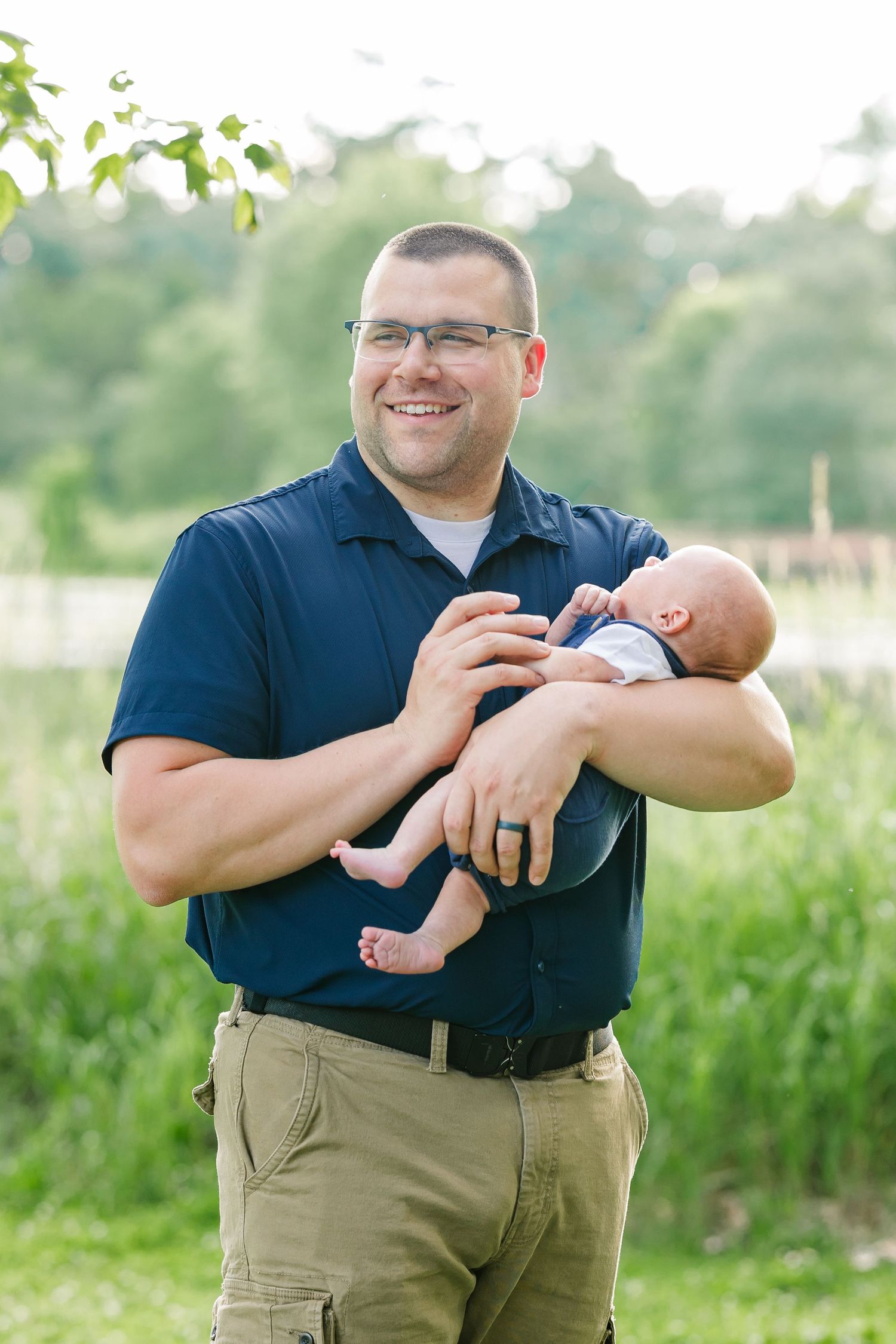Dad holding his baby boy during a summer extended family photo session at Veterans Acres Nature Center in Crystal Lake