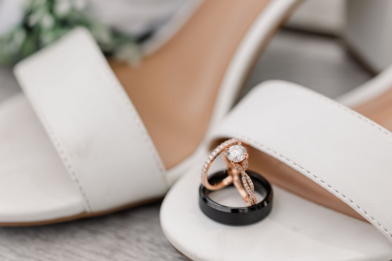 Monika and Rafael’s wedding rings arranged inside her ivory bridal shoes.