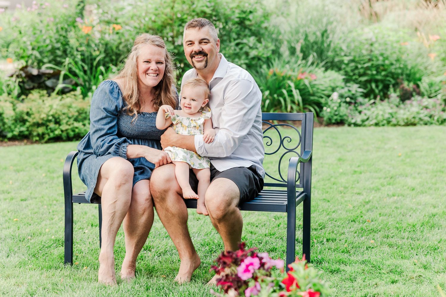 A family enjoying a relaxing moment together on a garden bench.