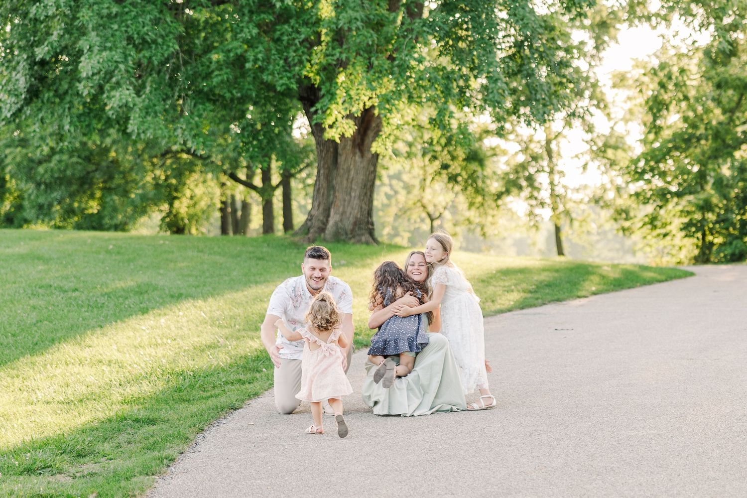 Candid moment of family enjoying playful time together on a park path.